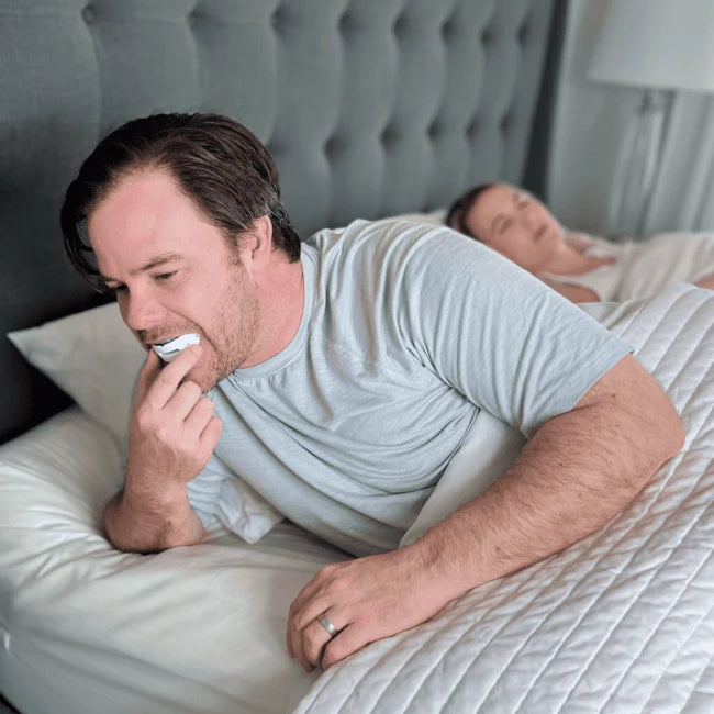 Man placing an anti-snoring mouthpiece before sleeping