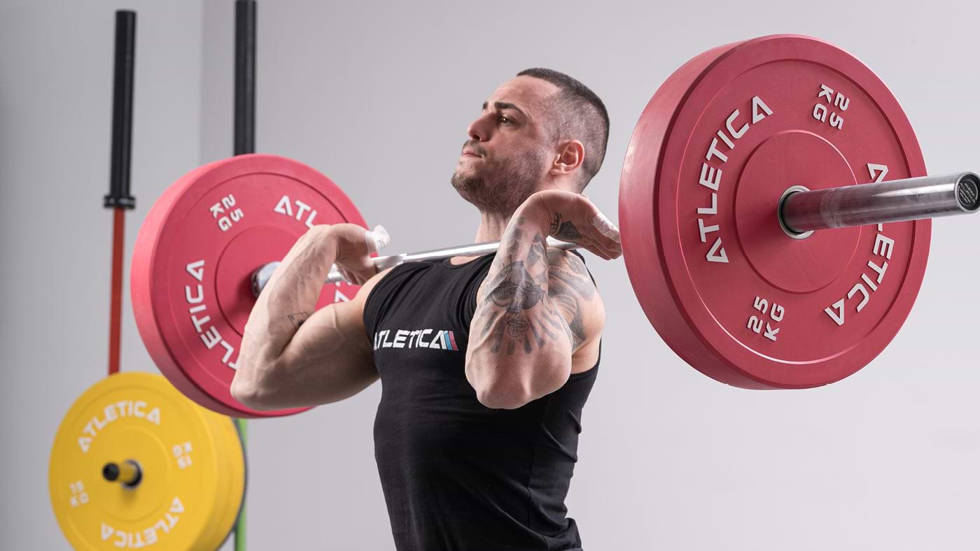 Athlet beim Langhanteltraining mit Atletica Langhantel und roten Color Bumper Plates