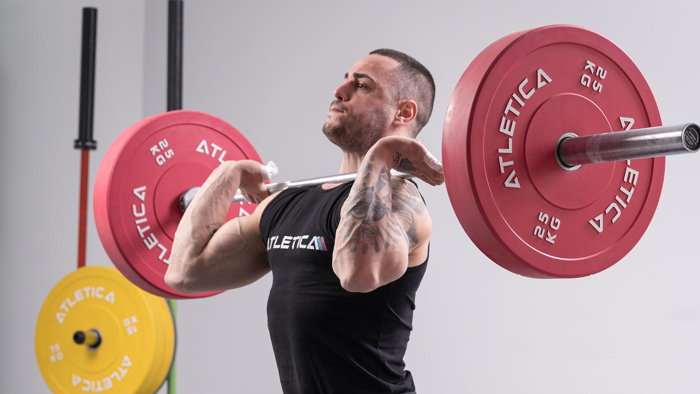 Athlet beim Langhanteltraining mit Atletica Langhantel und roten Color Bumper Plates