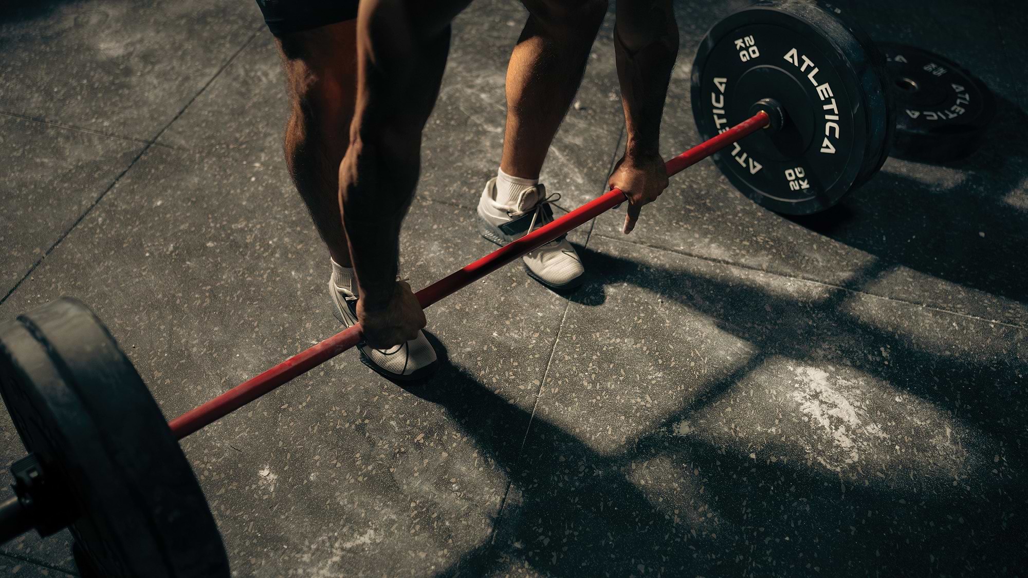 Athlet beim Kreuzheben mit Atletica Langhantel und Bumper Plates