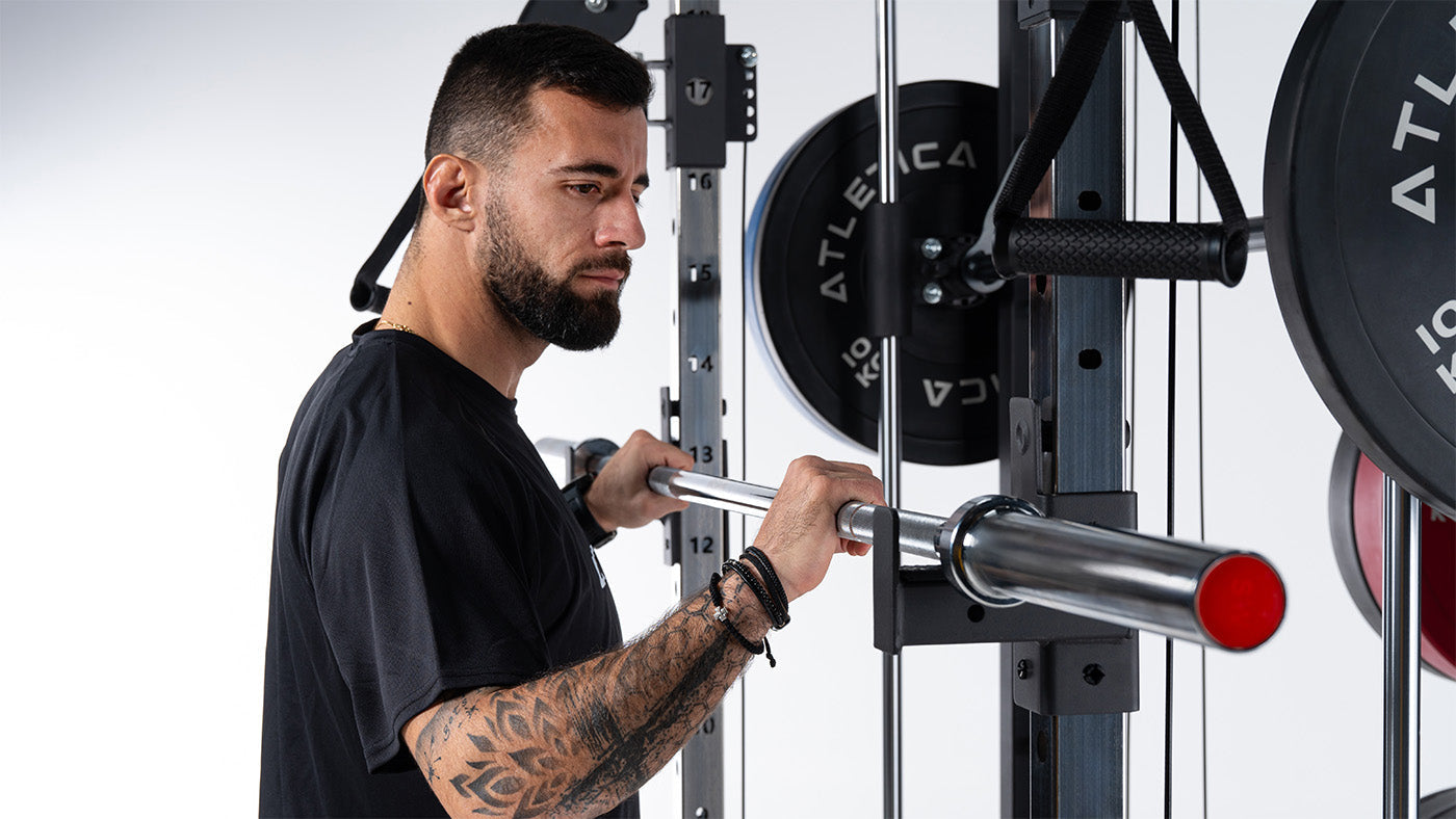 Athlet nimmt eine Atletica Hantelstange vom Power Rack