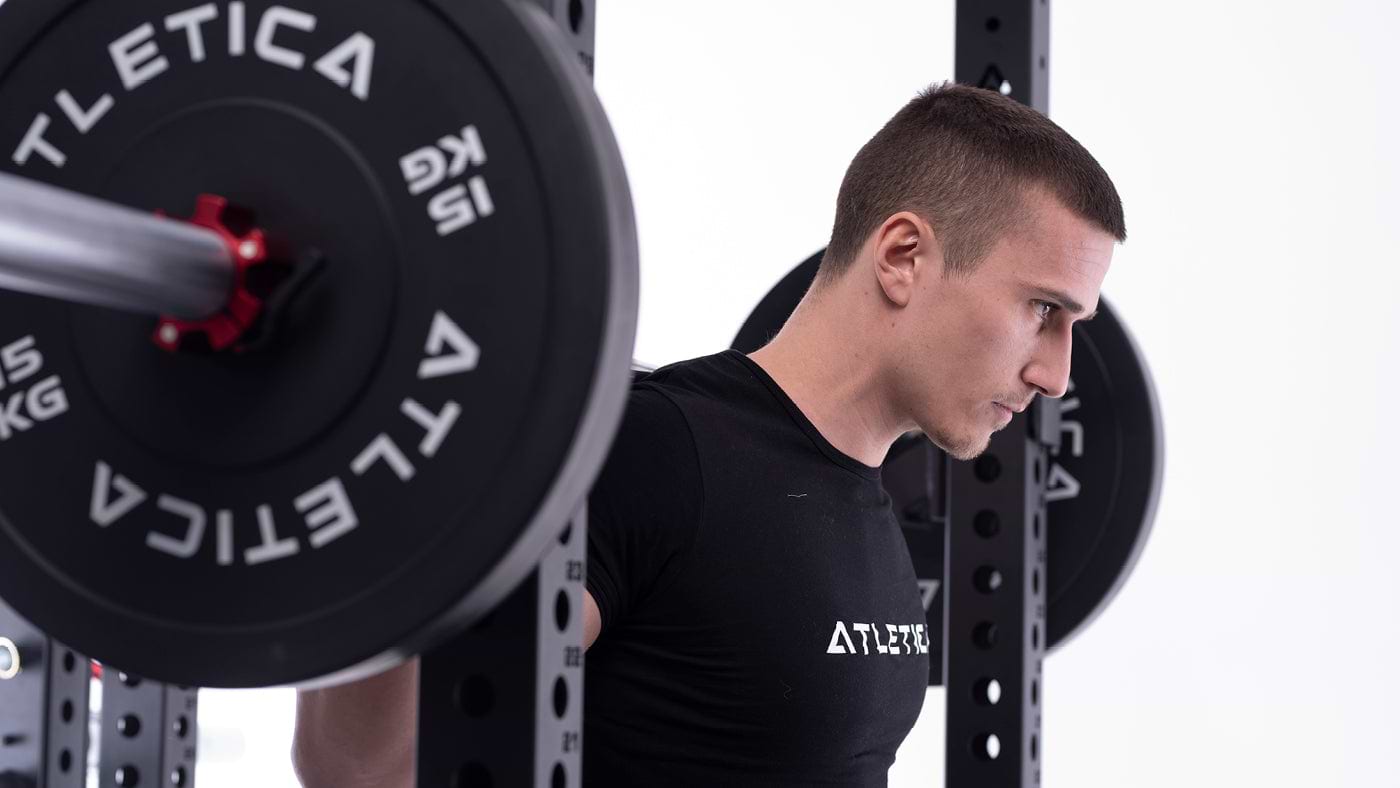 Kniebeuge mit Langhantel und ATLETICA Bumper Plates im Fitnessraum zuhause