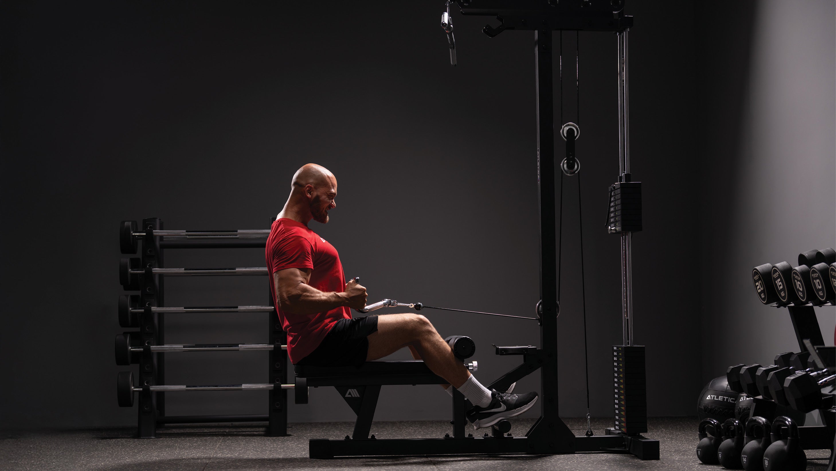 Man performing rows on the Atletica cable machine with weight stack