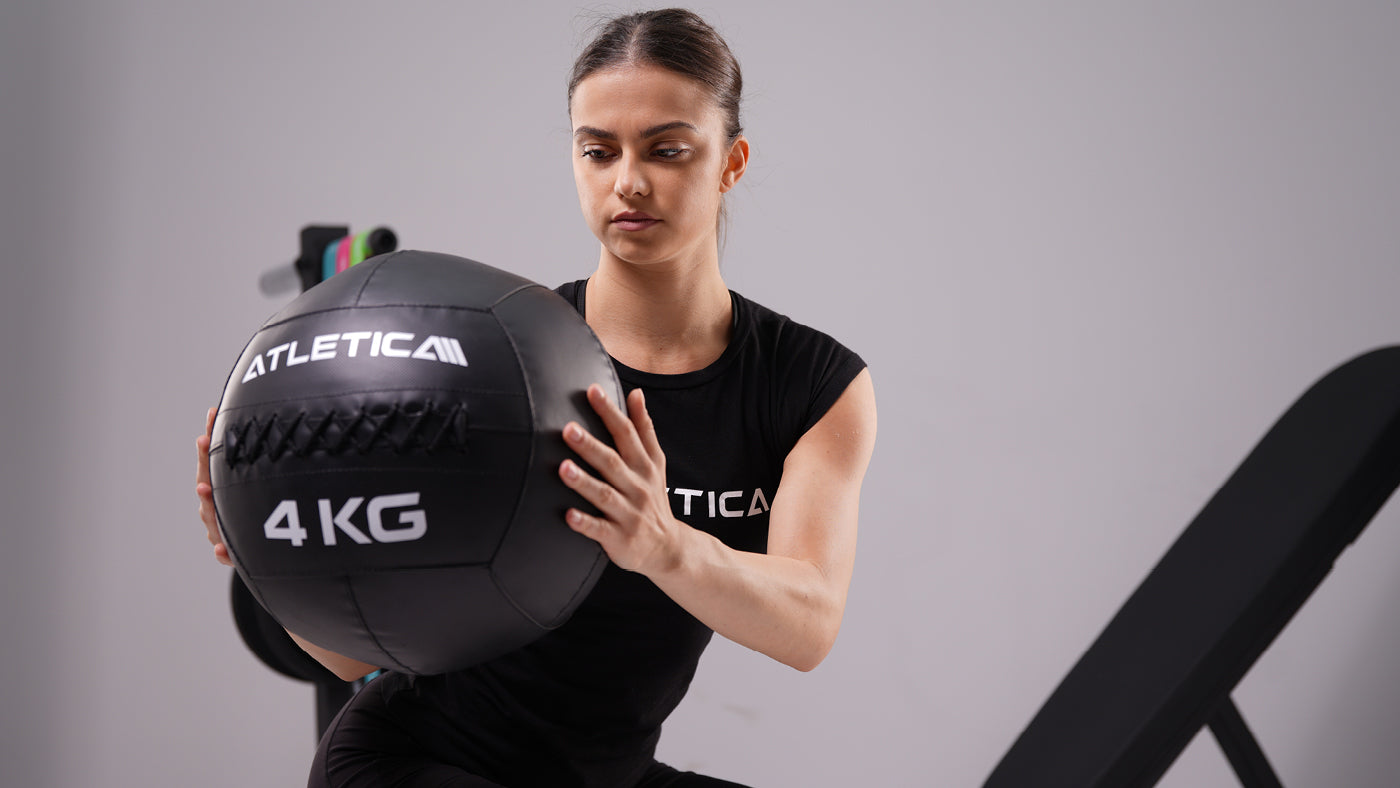 Woman training rotation with a 4 kg Atletica wall ball during functional training
