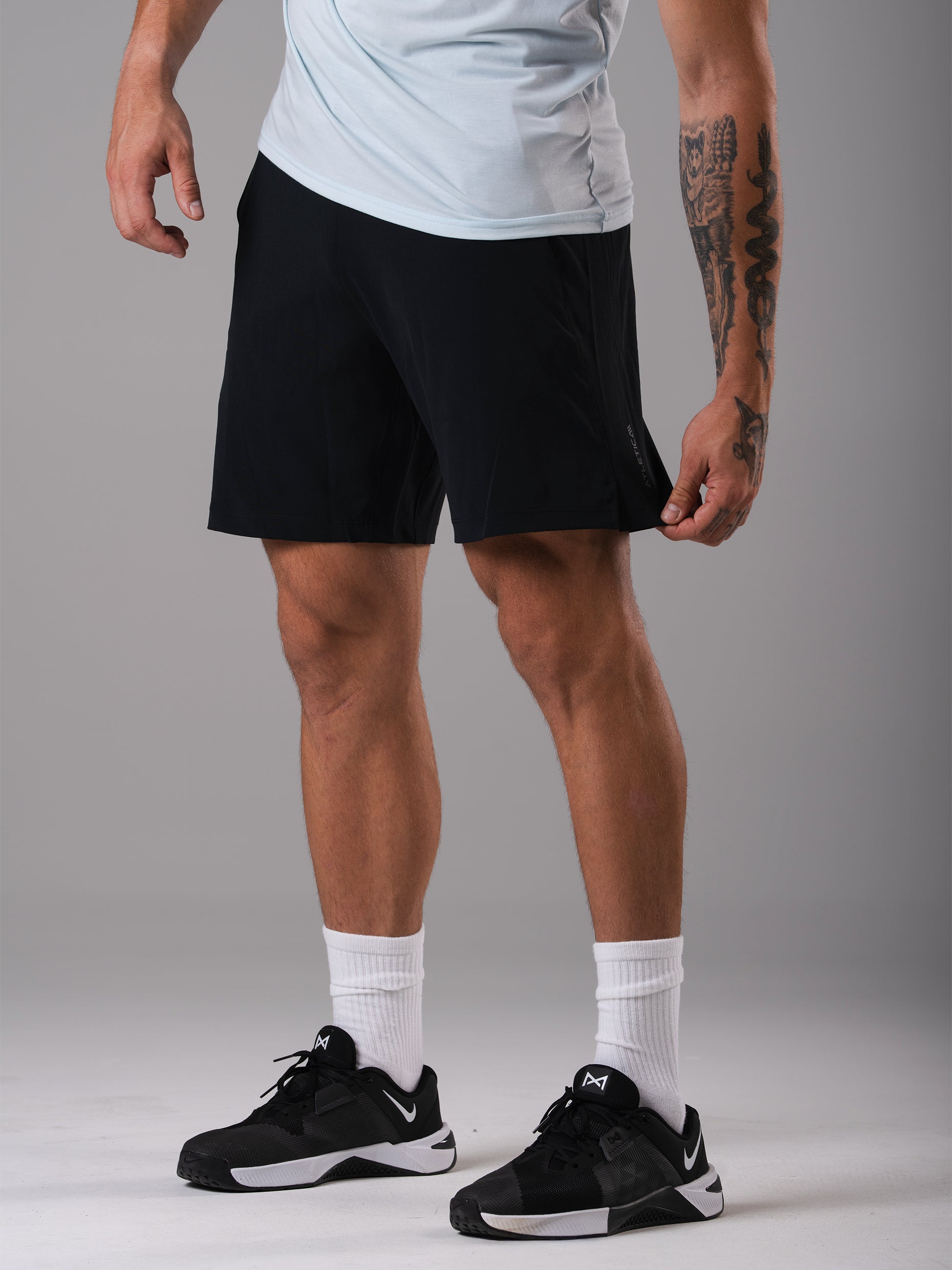 Frontansicht der schwarzen Flex Train Shorts von Atletica mit blauem T-Shirt