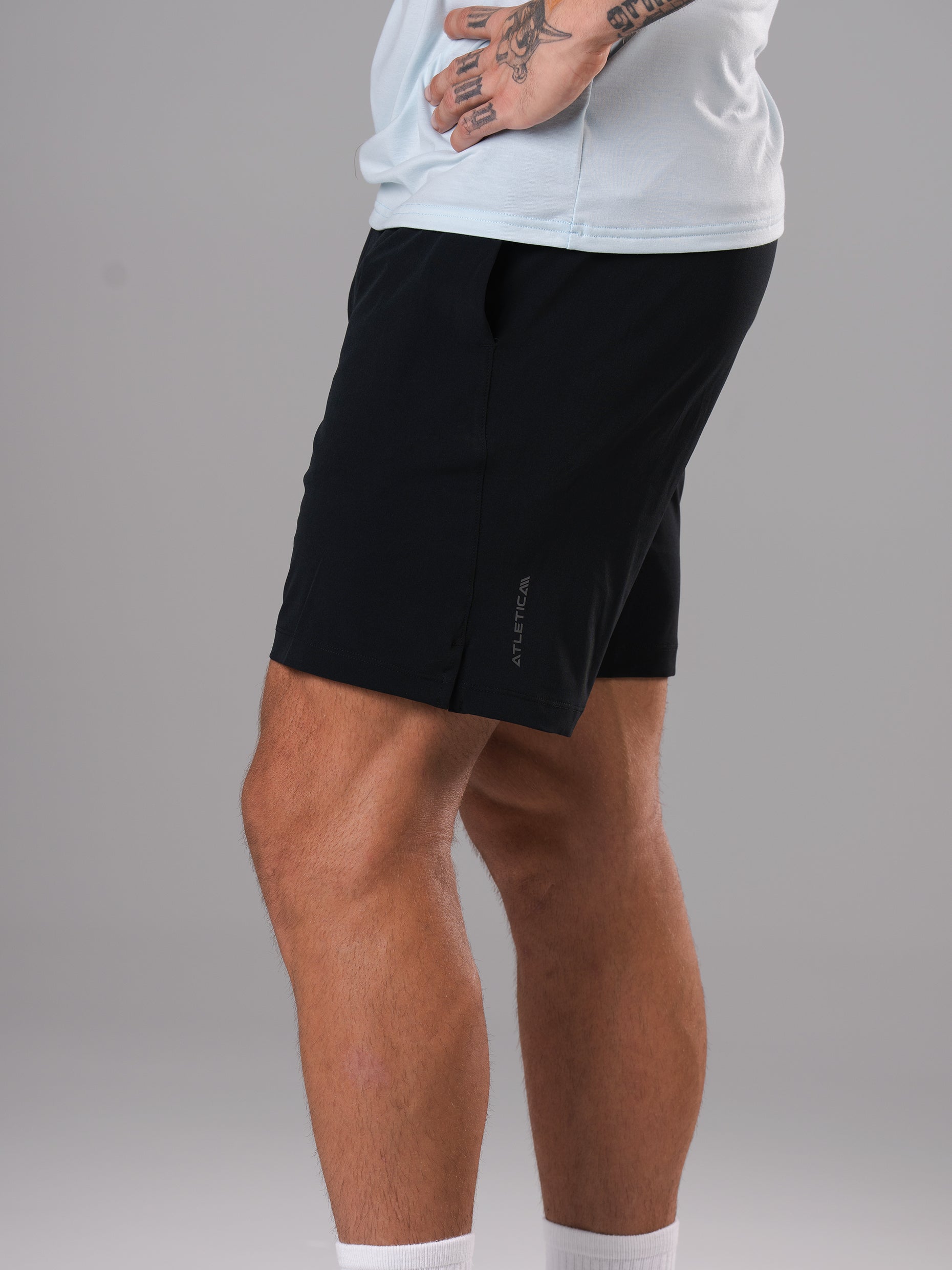 Seitenansicht der schwarzen Flex Train Shorts von Atletica am Model