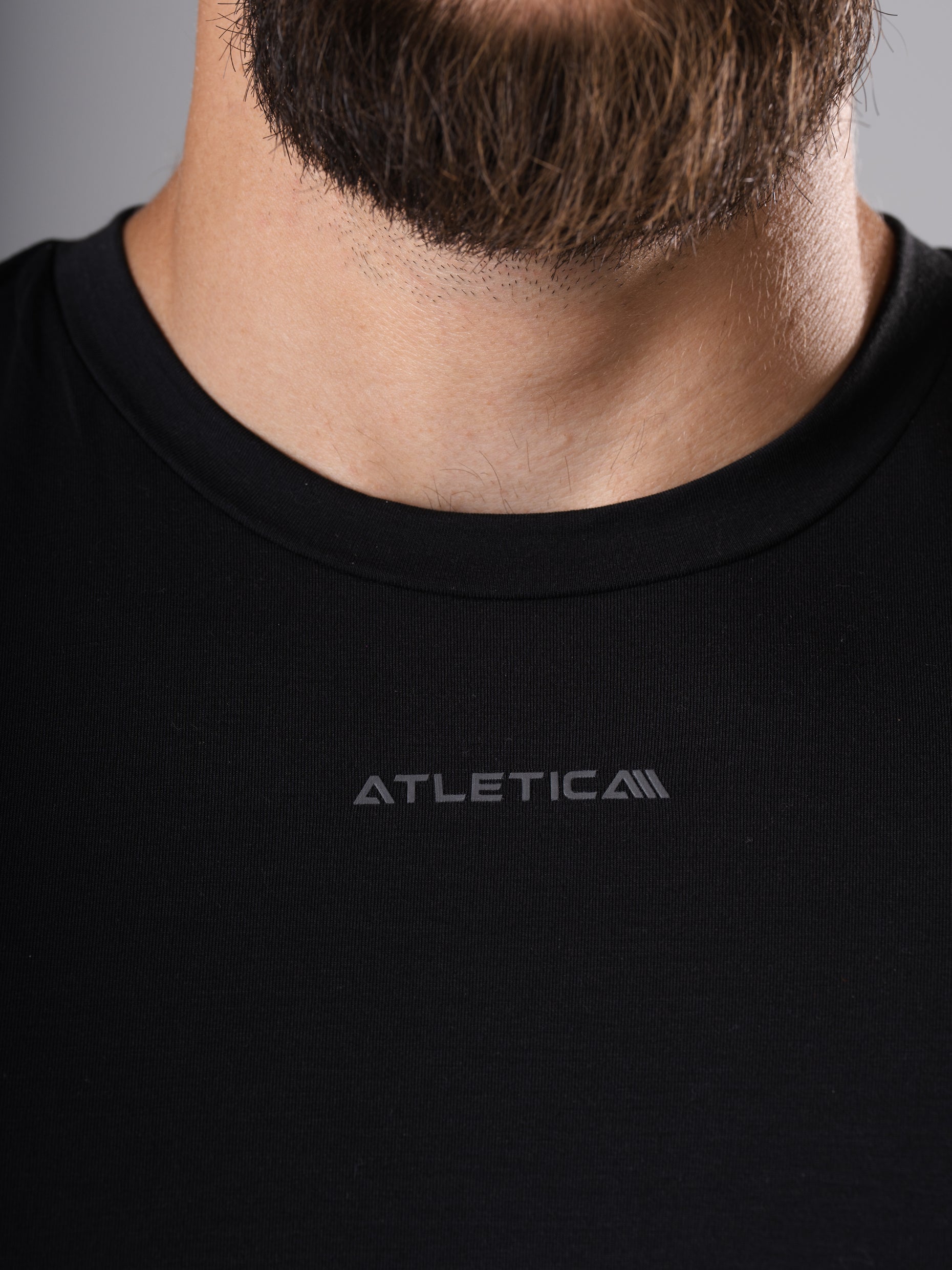 Nahaufnahme des Rundhalsausschnitts mit Logo am schwarzen Flex Train T-Shirt von Atletica