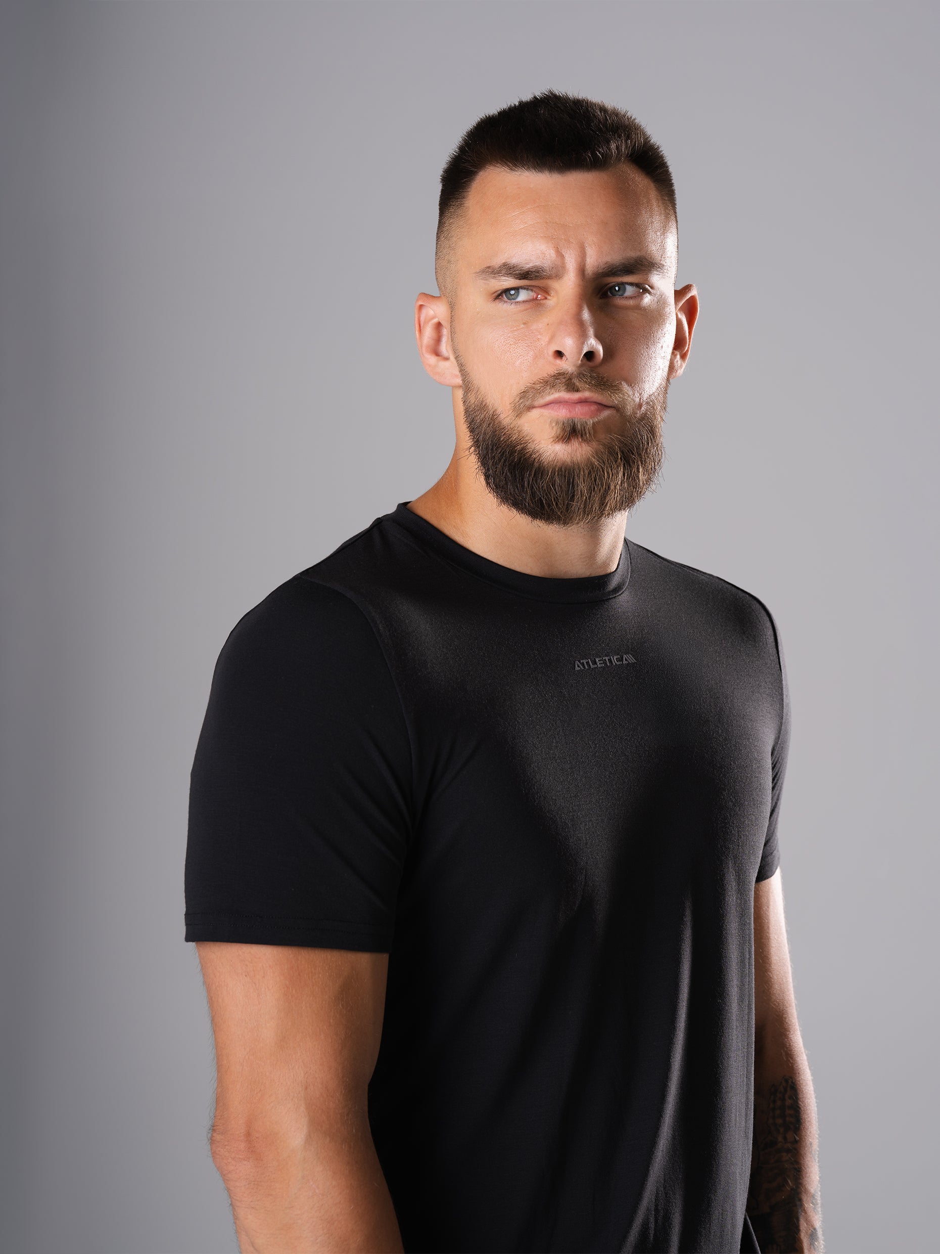 Mann im schwarzen Flex Train T-Shirt von Atletica, schräge Ansicht des Oberkörpers