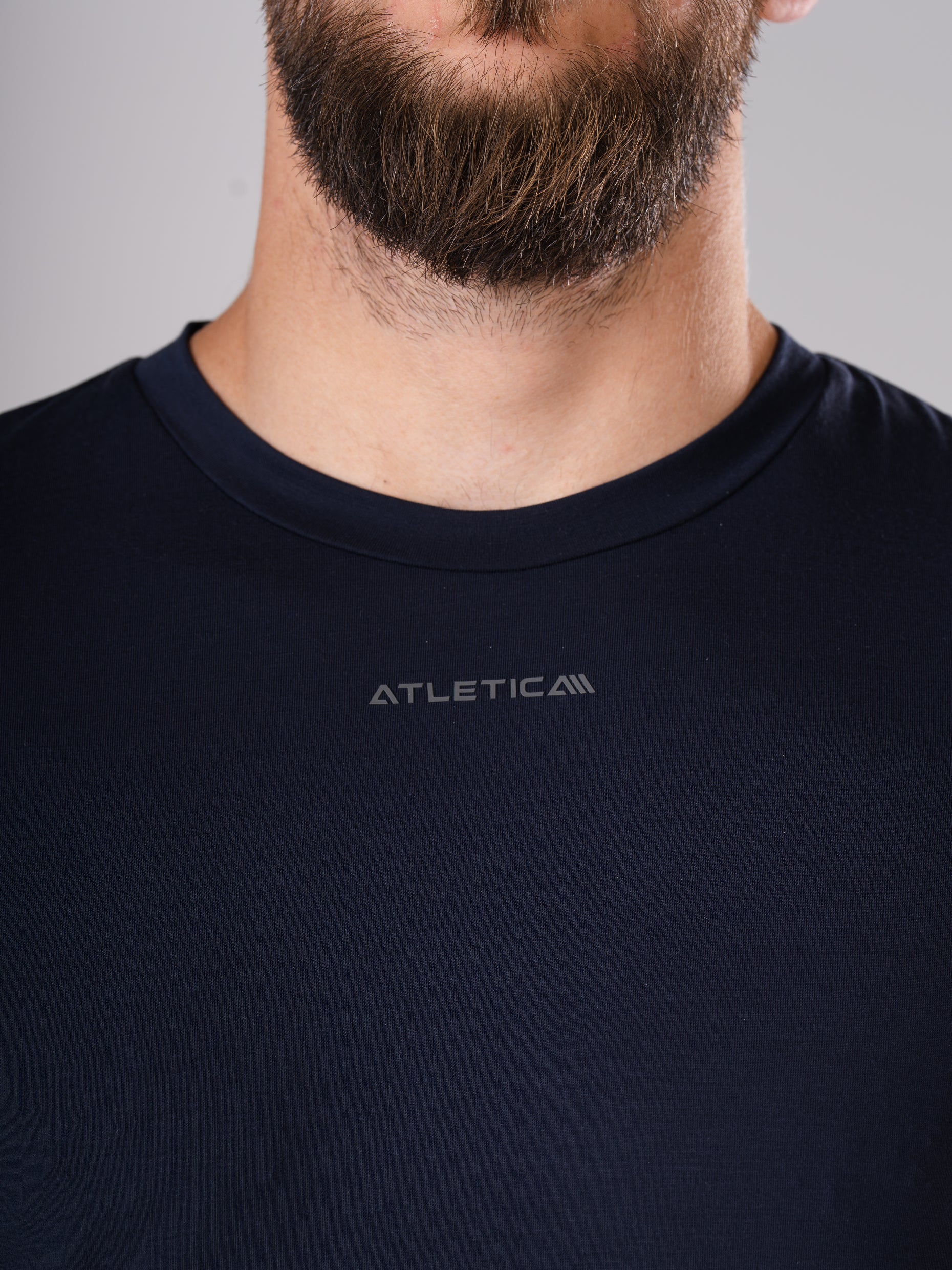 Nahaufnahme des Rundhalsausschnitts mit Logo am Flex Train T-Shirt in Dark Navy von Atletica