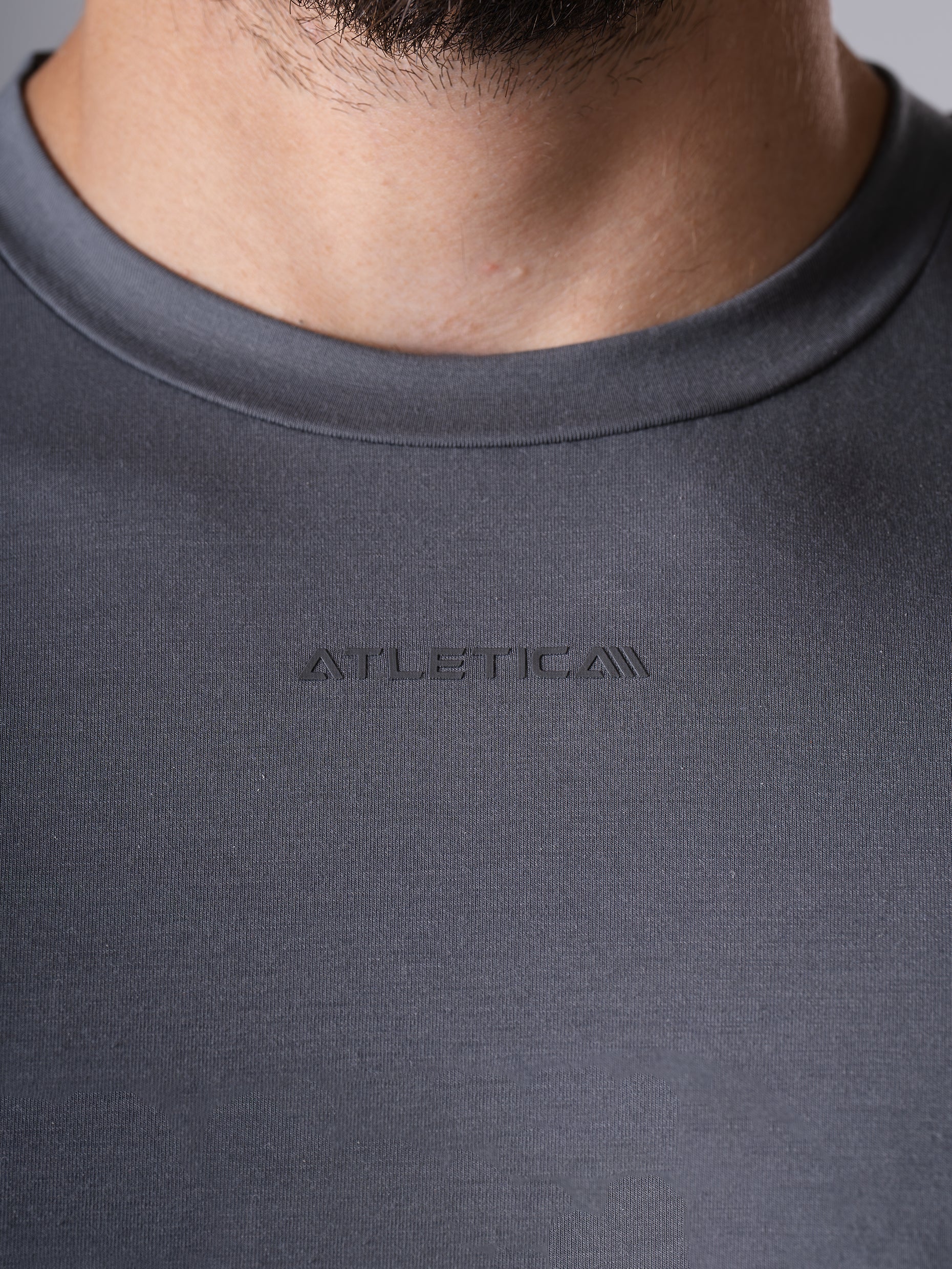 Nahaufnahme des Rundhalsausschnitts mit Logo am Flex Train T-Shirt in CastleRock Grey von Atletica