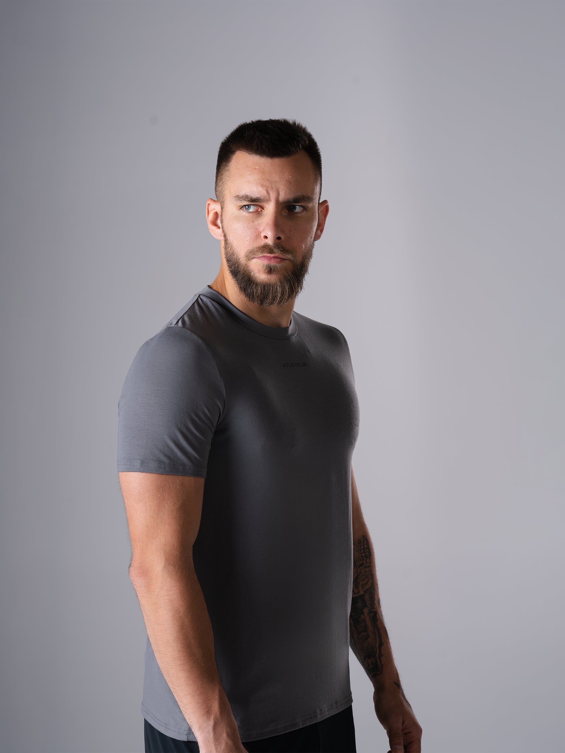 Mann im Flex Train T-Shirt in CastleRock Grey von Atletica, seitliche Ansicht