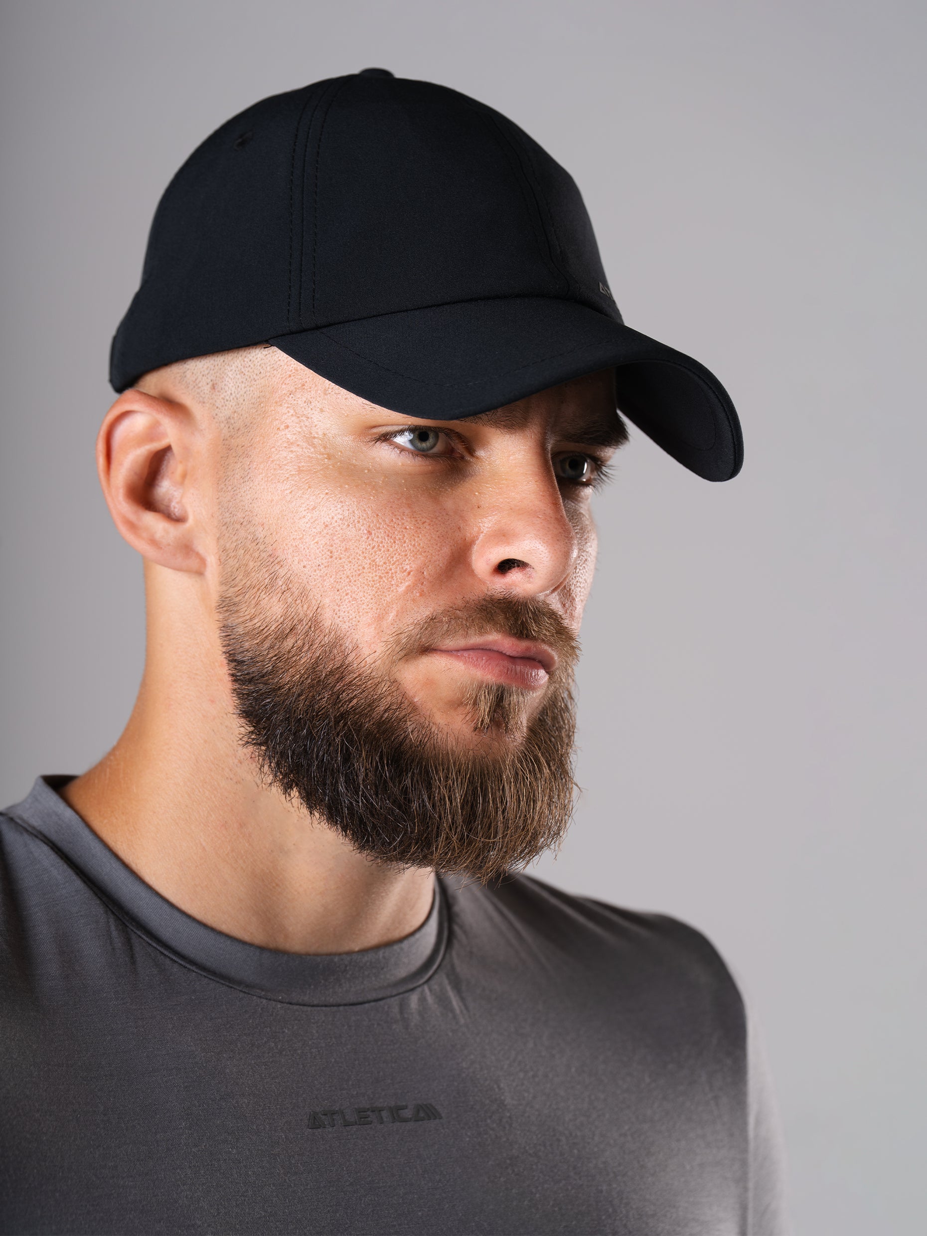 Mann im Flex Train T-Shirt in CastleRock Grey und mit schwarzem Cool Cap von Atletica, Nahaufnahme