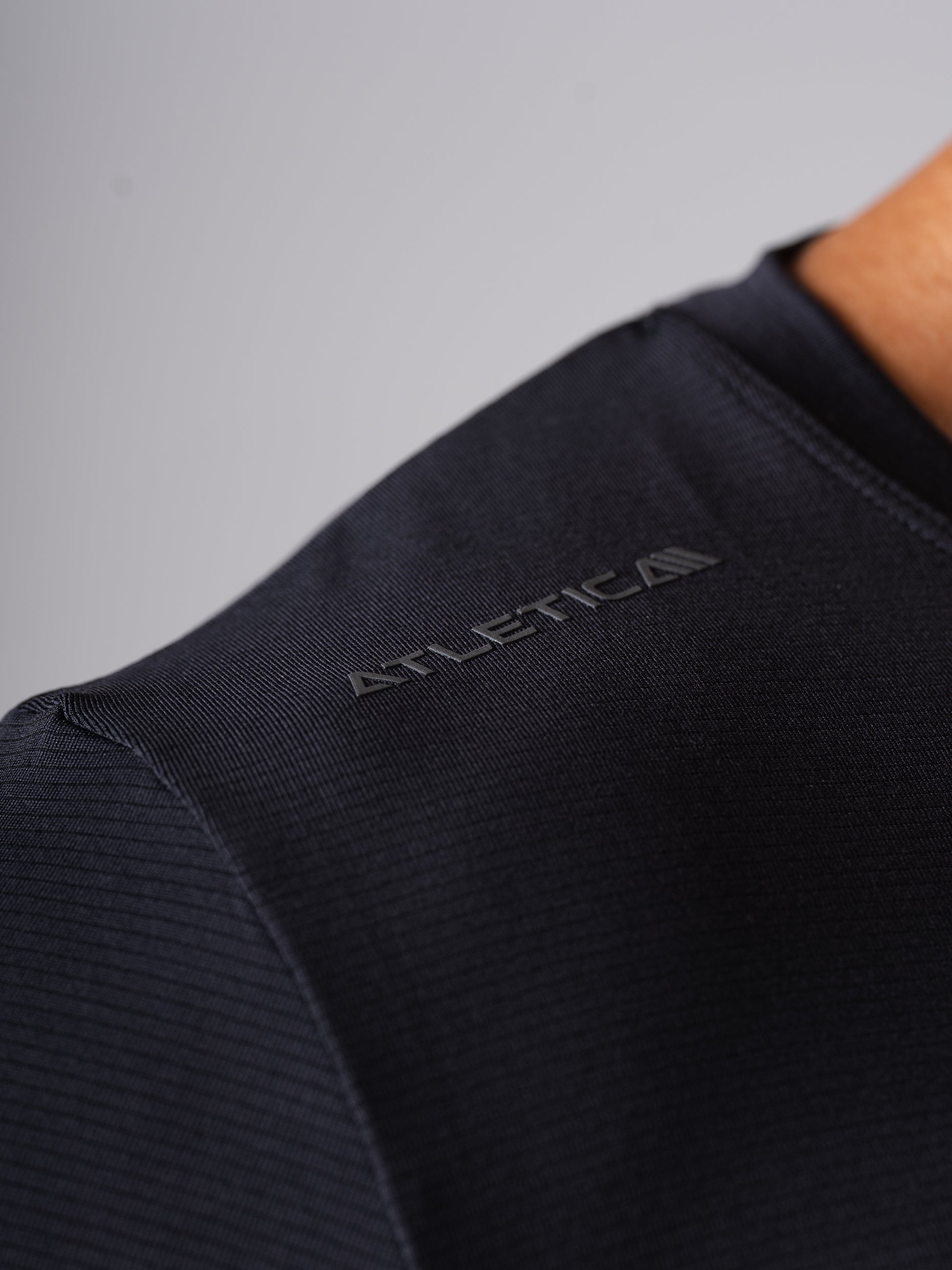 Detailansicht des schwarzen Hard Lift T-Shirts von Atletica mit Logo an der Schulter