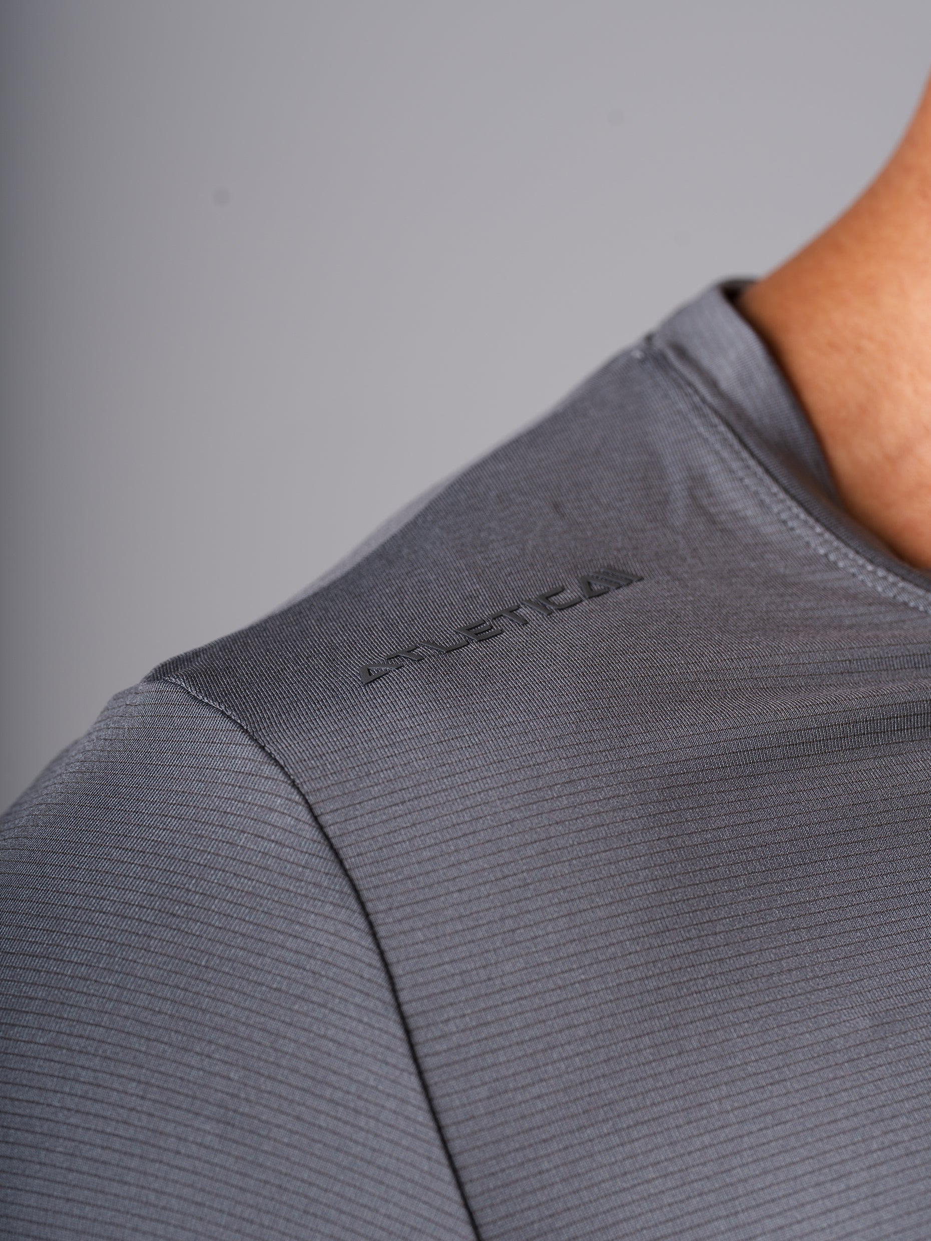 Detailansicht des Hard Lift T-Shirts in CastleRock Grey von Atletica mit Logo an der Schulter