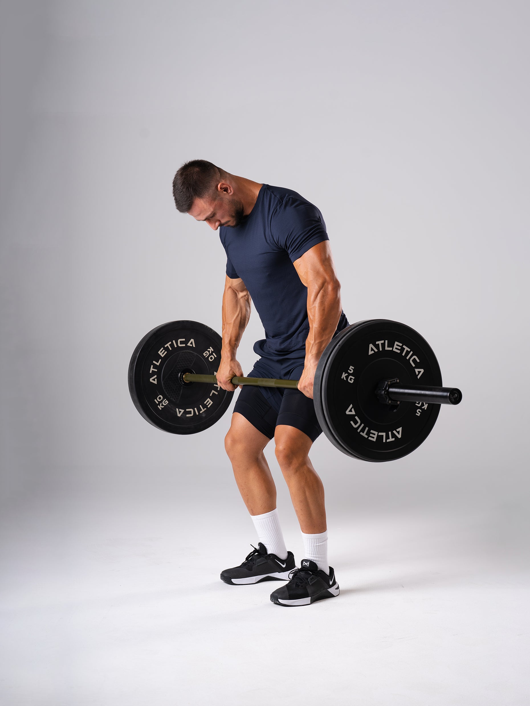 Mann im Hard Lift T-Shirt in Dark Navy von Atletica beim Kreuzheben mit Langhantel