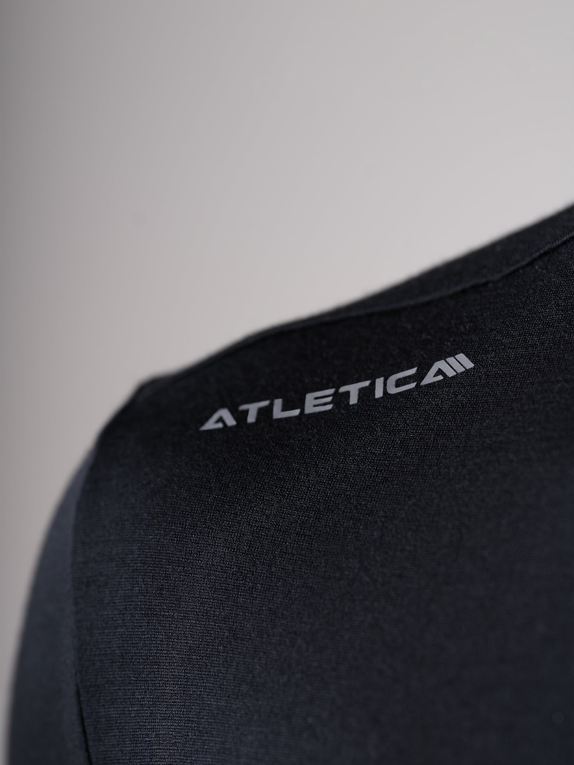 Detailansicht des schwarzen Ascend Merino Wool T-Shirts von Atletica mit Logo an der Schulter