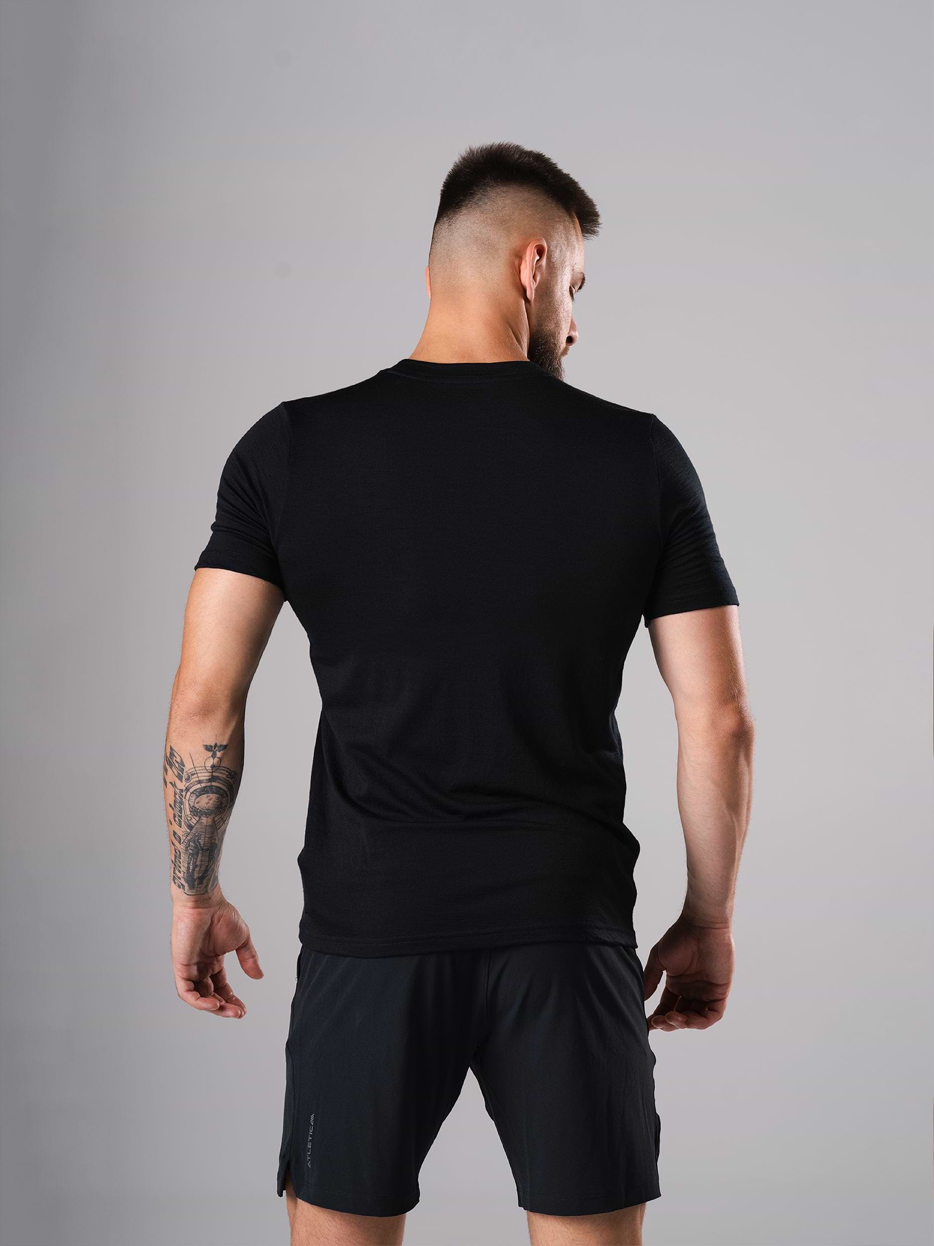 Rückansicht des Ascend Merino Wool T-Shirts in Schwarz von Atletica am Model