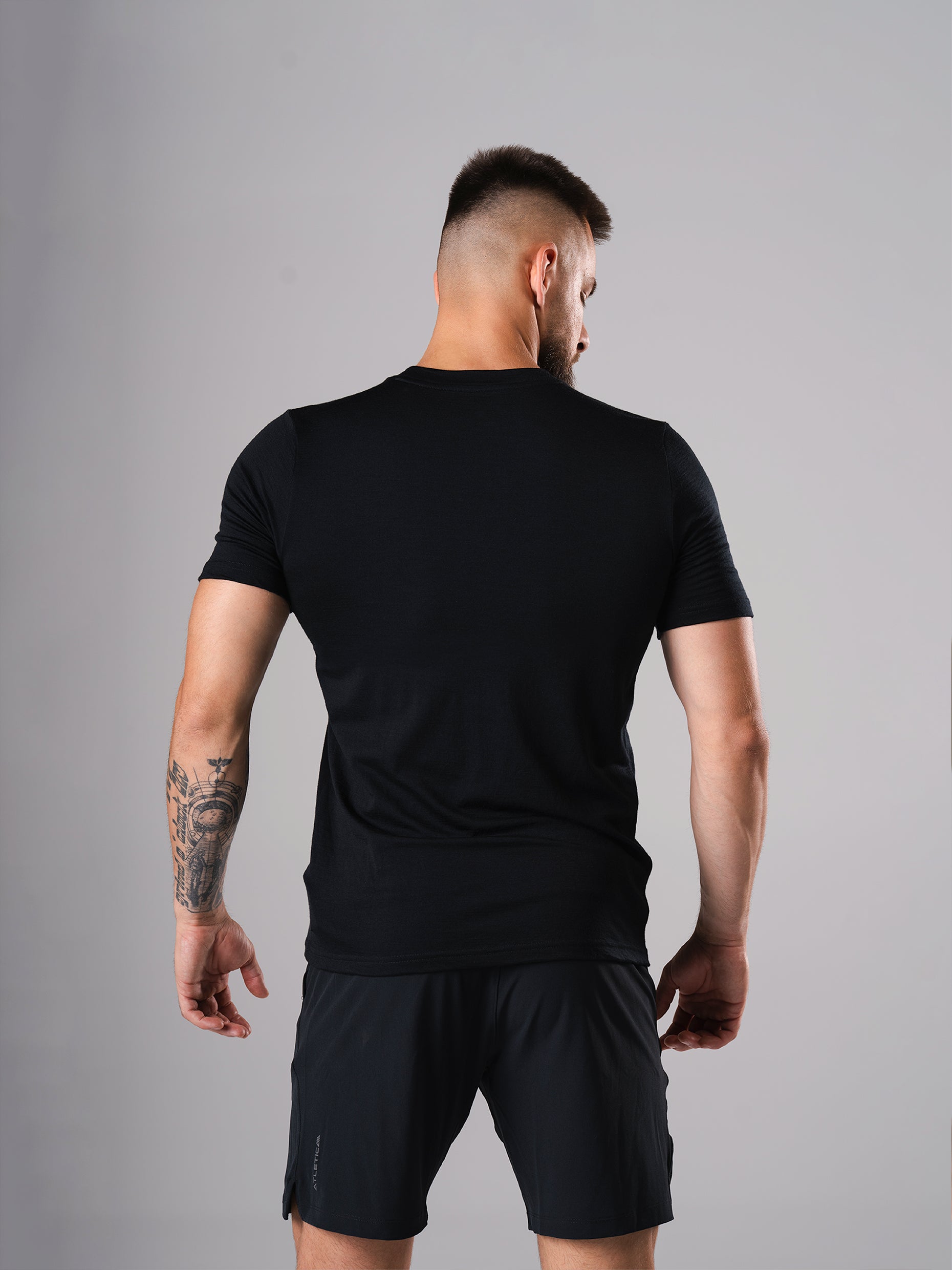 Rückansicht des Ascend Merino Wool T-Shirts in Schwarz von Atletica am Model