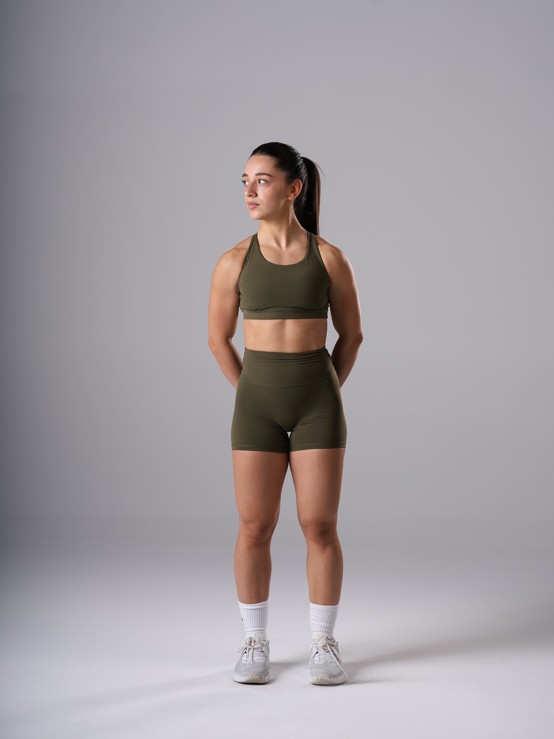 Frau in den Power Form Short Tights in Olive Night von Atletica mit Power Form Bra in Olive Night, Ganzkörperansicht