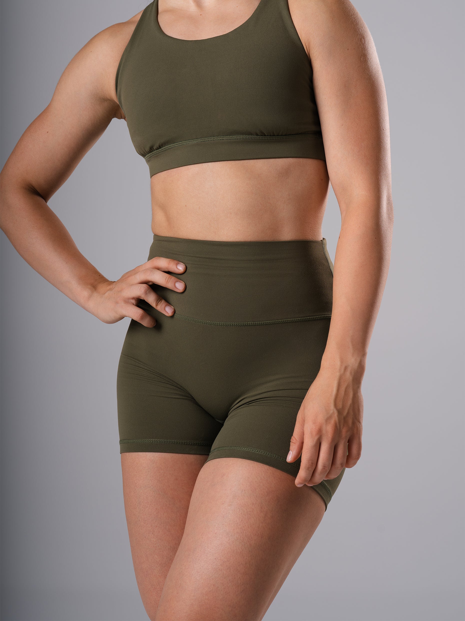 Frau in den Power Form Short Tights in Olive Night von Atletica mit Power Form Bra in Olive Night, schräge Frontansicht