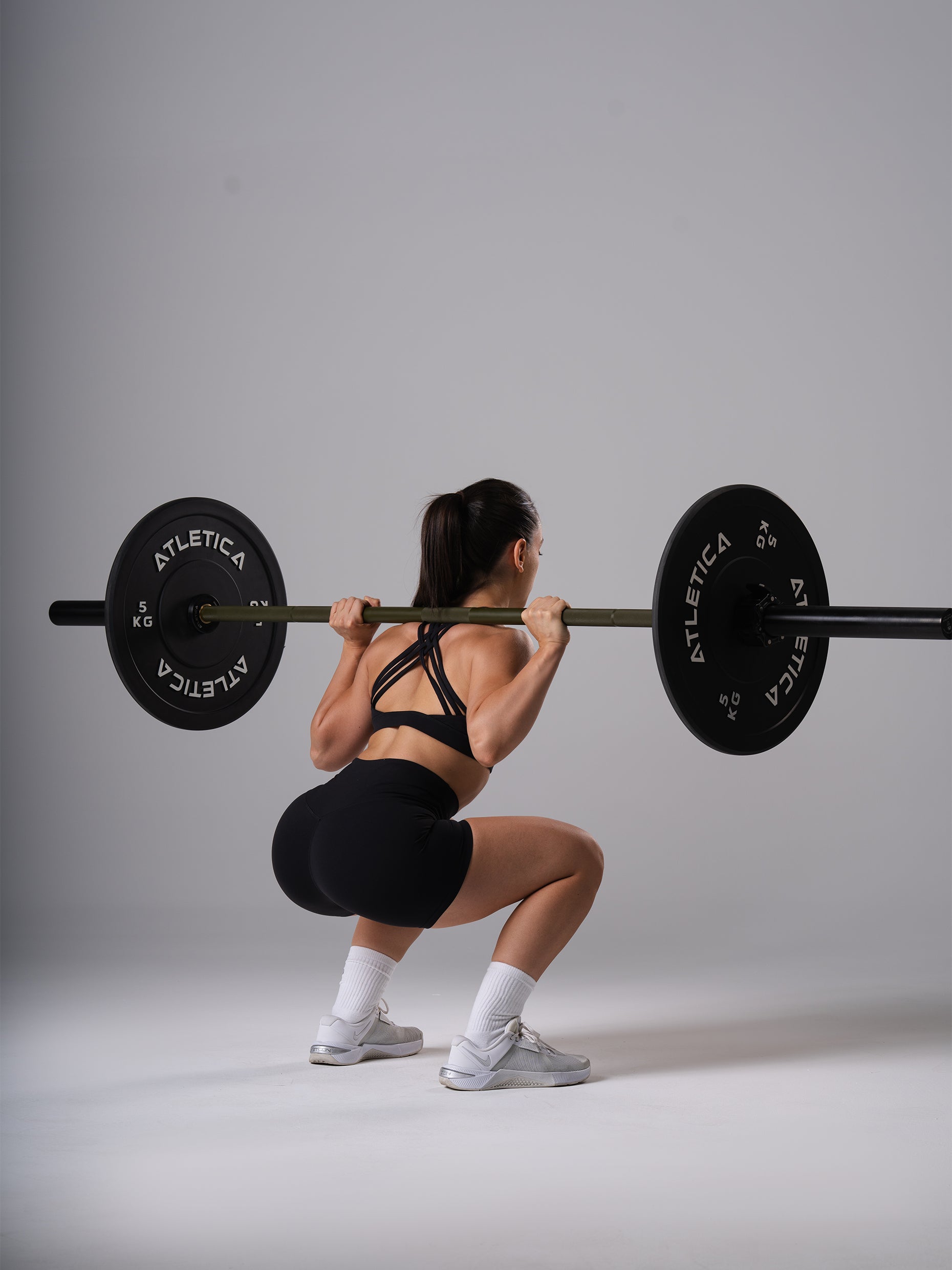 Frau in den schwarzen Power Form Short Tights von Atletica bei der Kniebeuge mit Langhantel