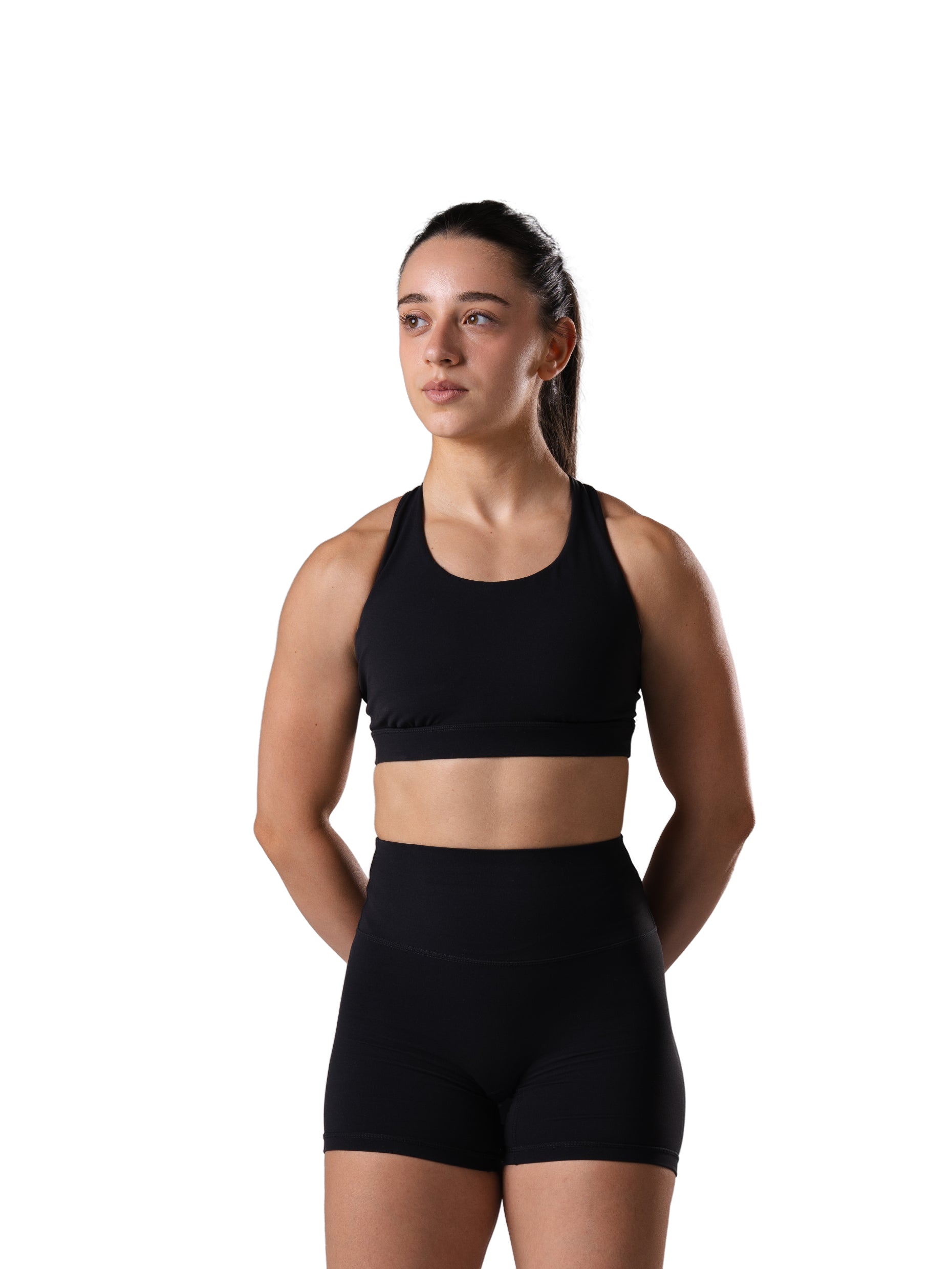Frau im Power Form Bra in Schwarz von Atletica mit passenden Shorts, Frontansicht