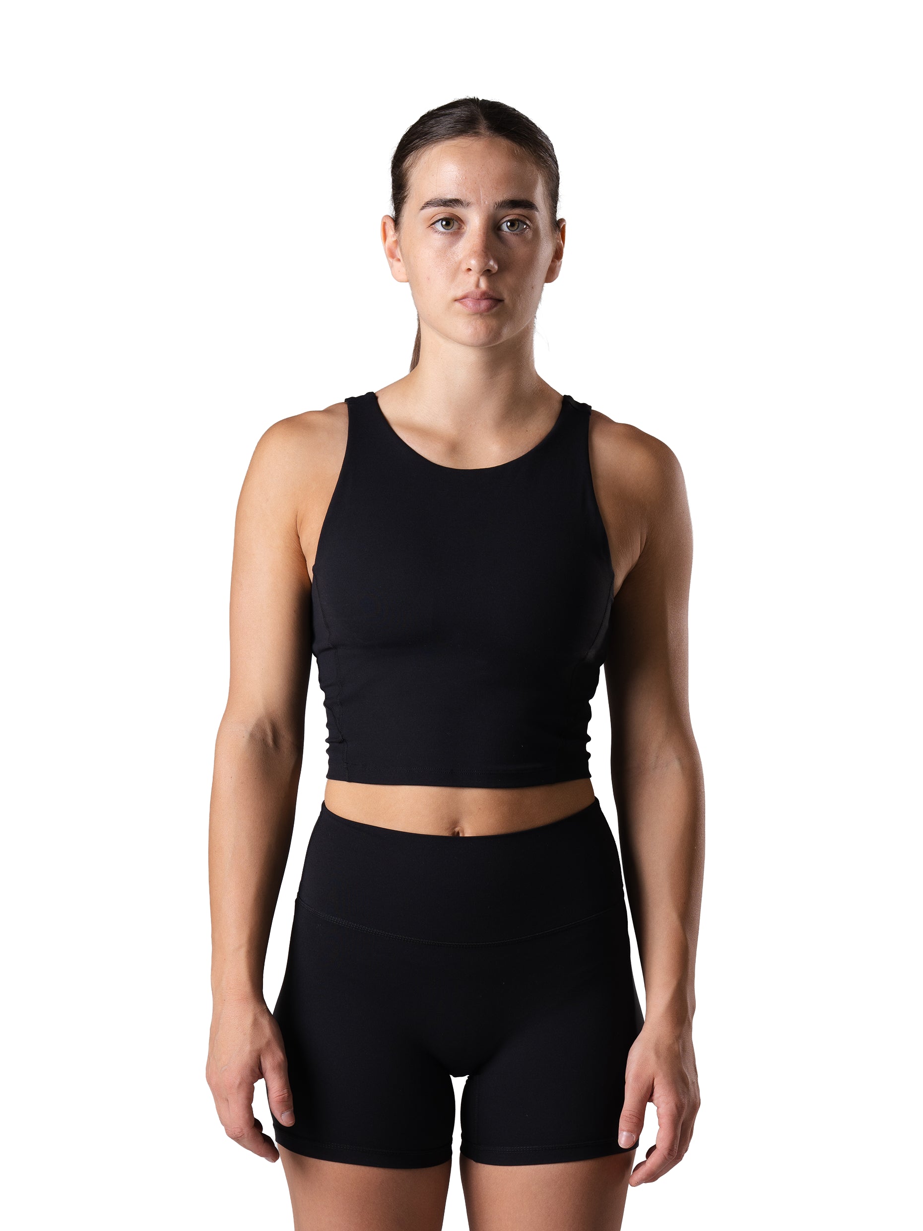 Frau im Power Form Tank Top Bra in Schwarz von Atletica mit passenden Shorts, Frontansicht