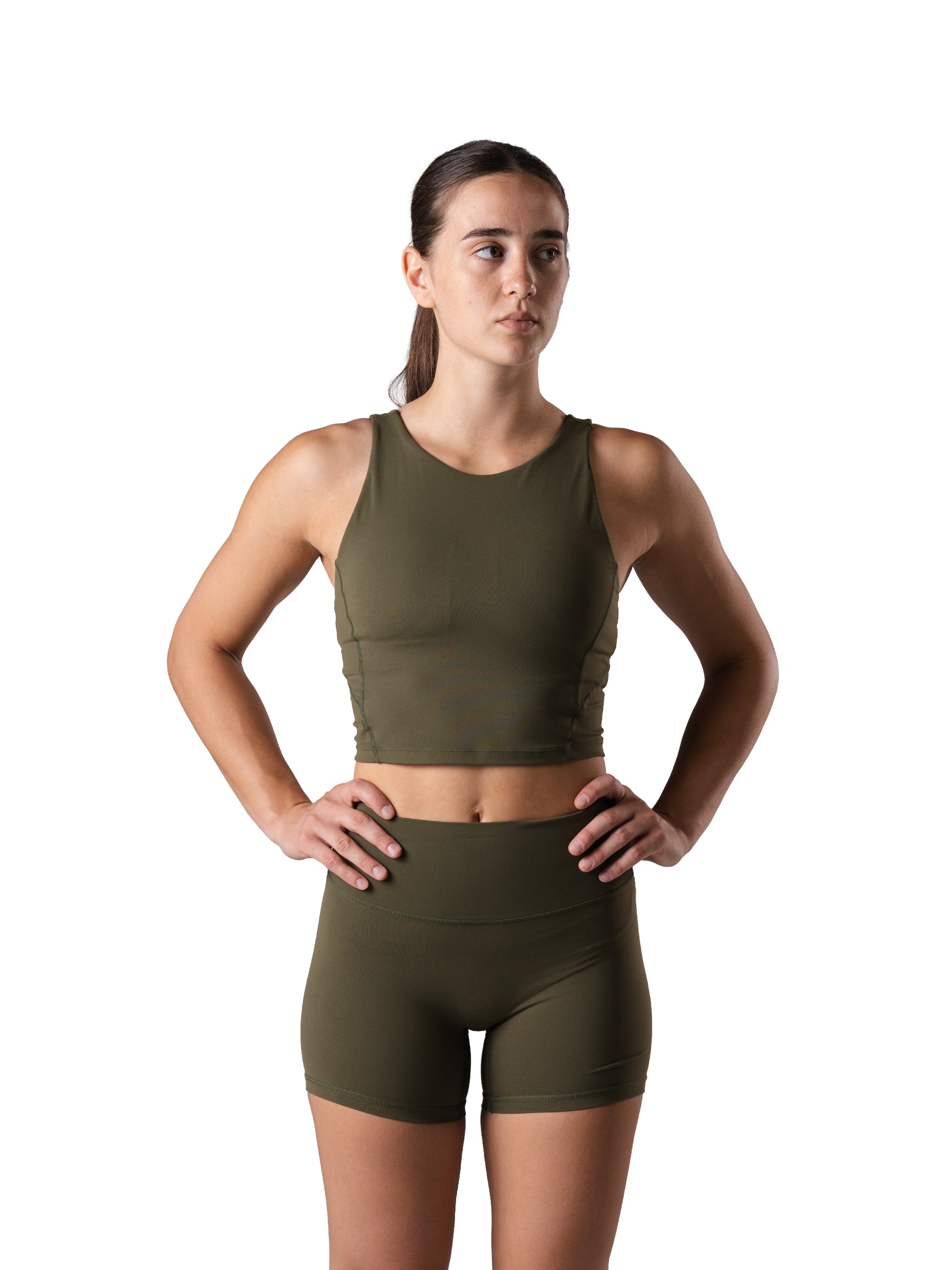 Frau im Power Form Tank Top Bra in Olive Night von Atletica mit passenden Shorts, Frontansicht