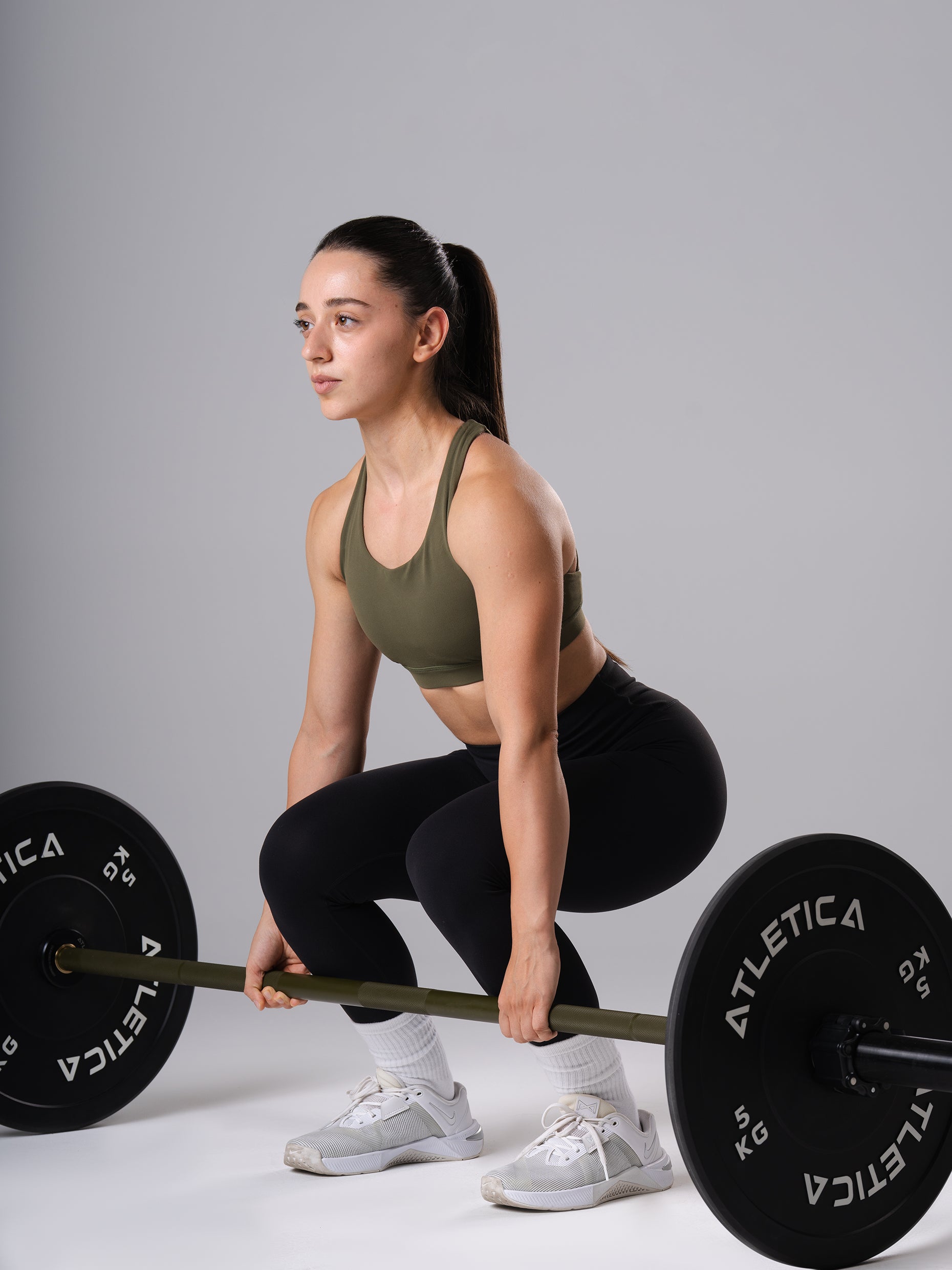 Frau in den schwarzen Power Form Tights von Atletica in der Startposition beim Kreuzheben mit Langhantel
