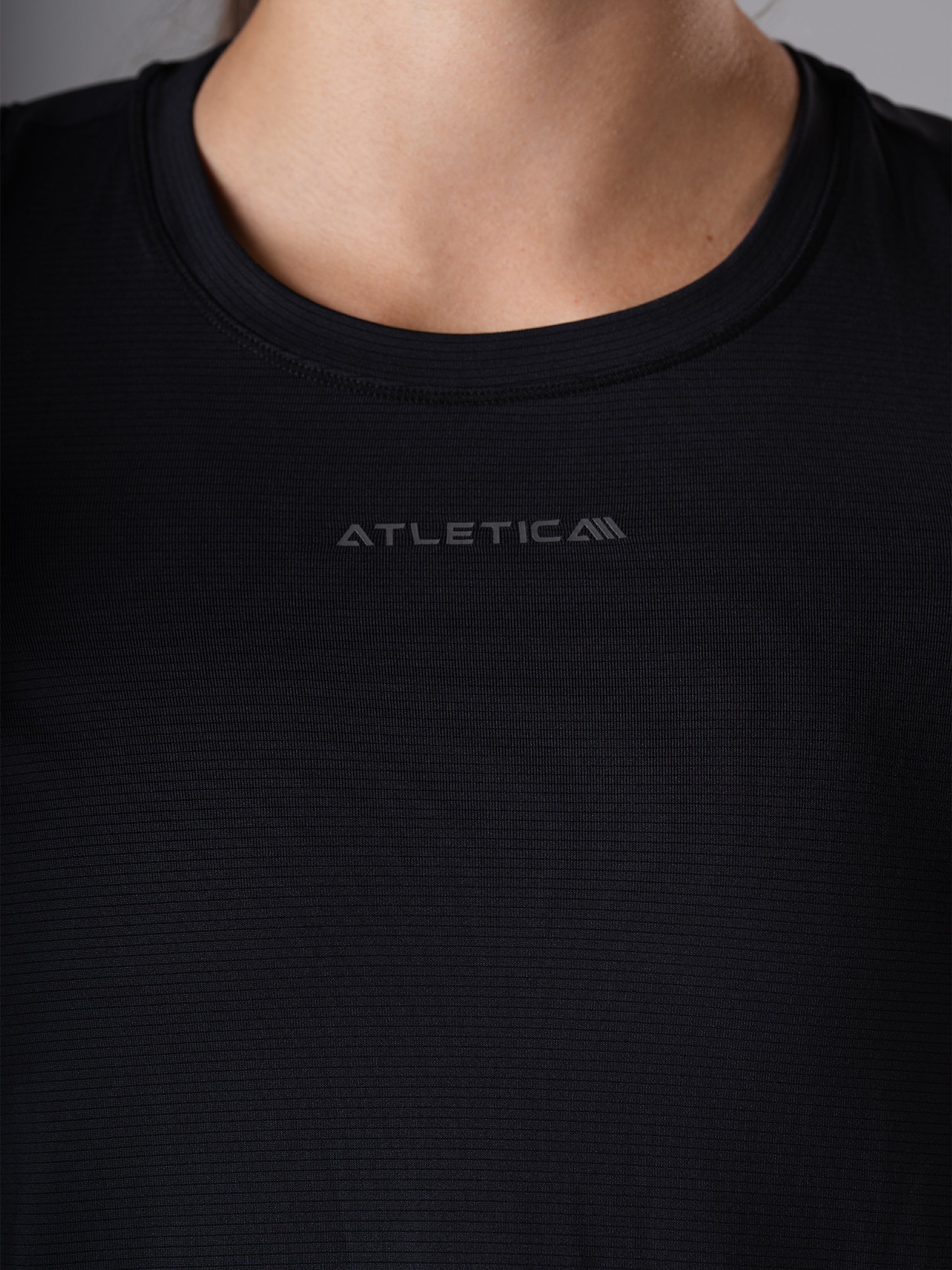 Nahaufnahme des Rundhalsausschnitts mit Logo am schwarzen Power Lift Tank Top von Atletica