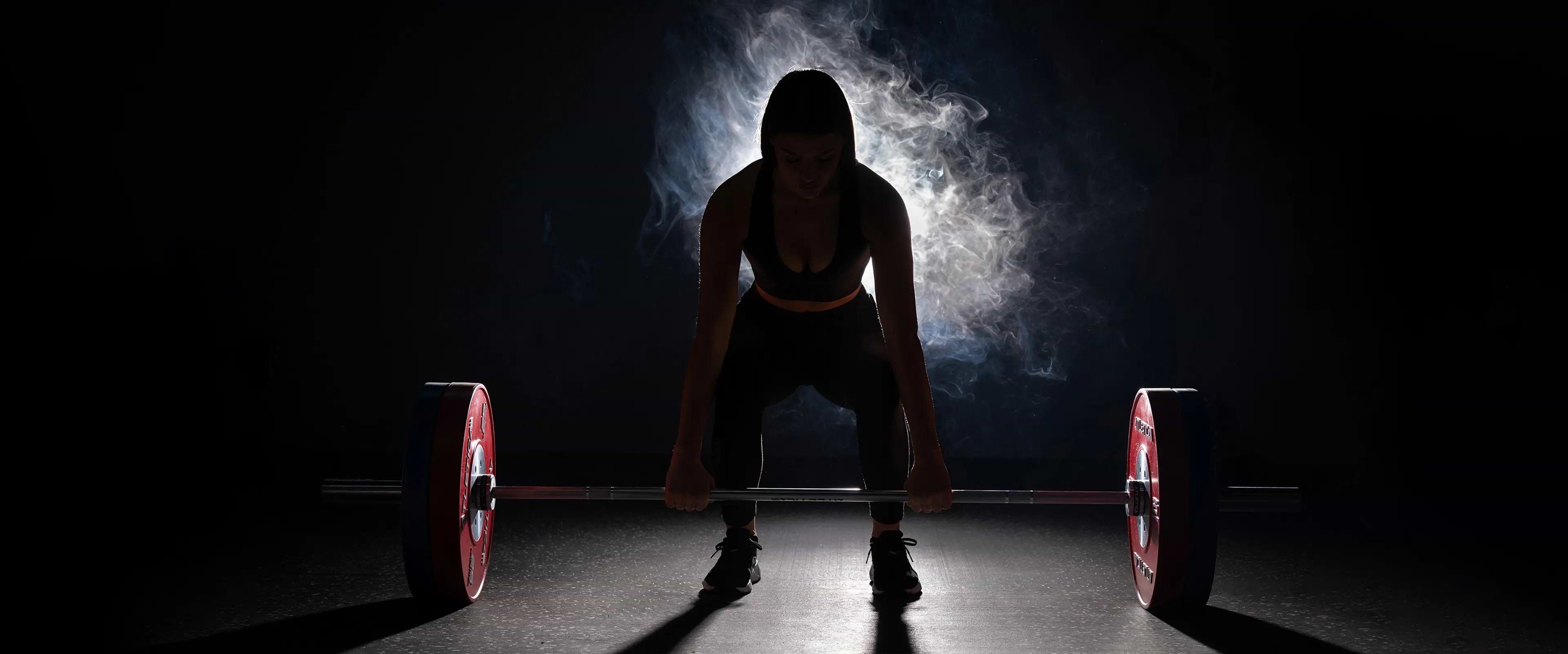 Athletin beim Kreuzheben mit Langhantel und Competition Bumper Plates Gewichten