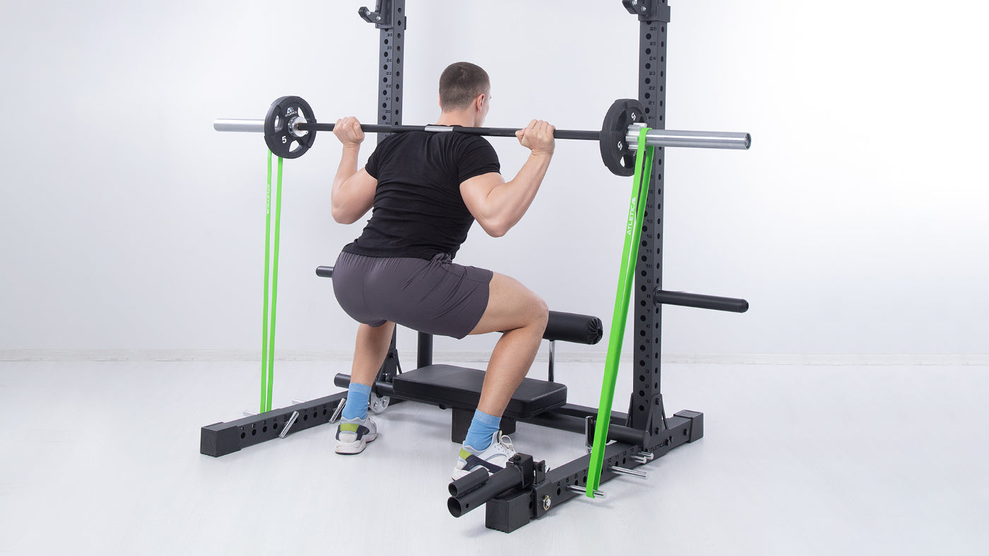 Kniebeugen am Squat Rack mit Widerstandsband
