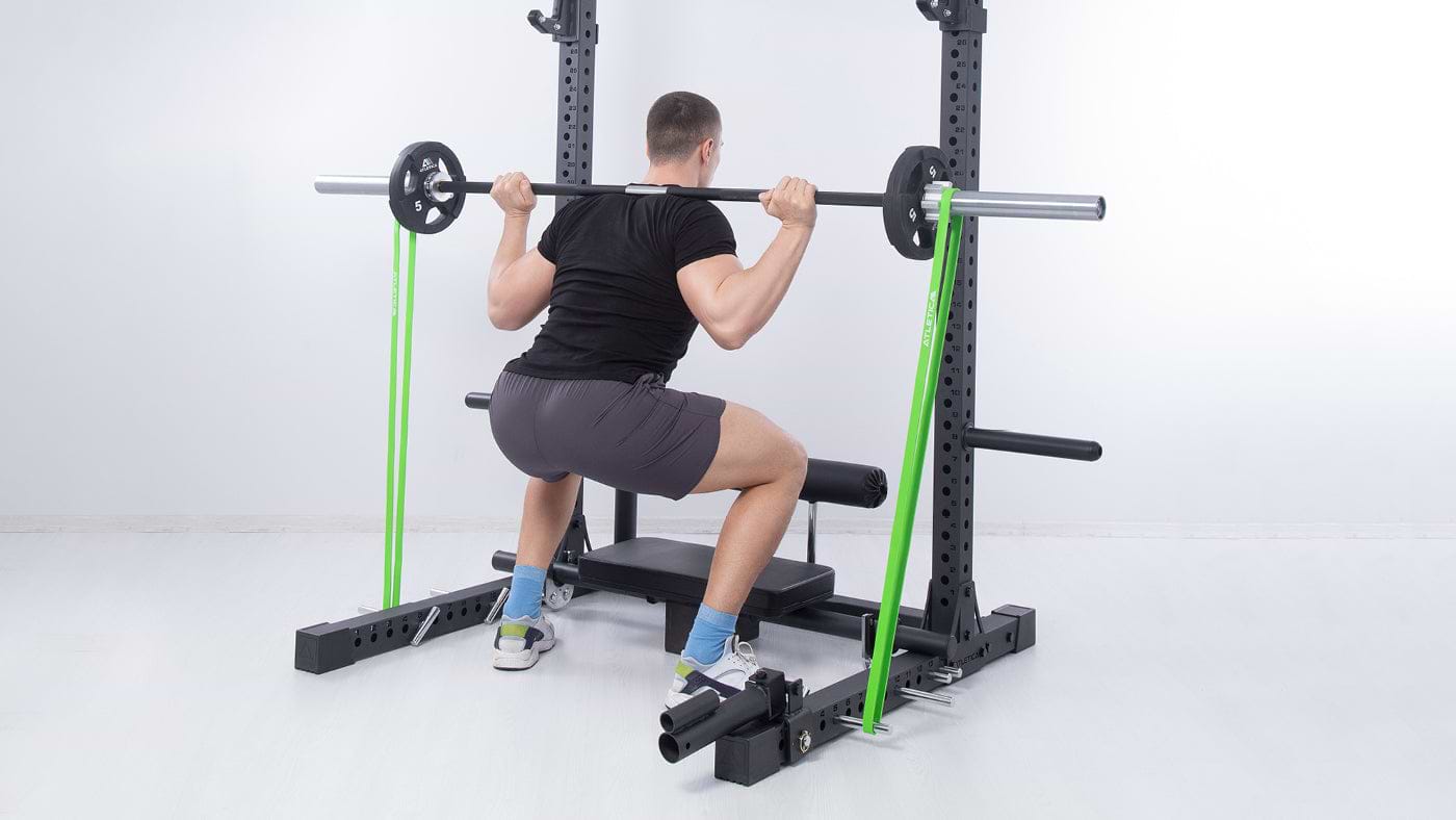 Kniebeugen am Squat Rack mit Widerstandsband