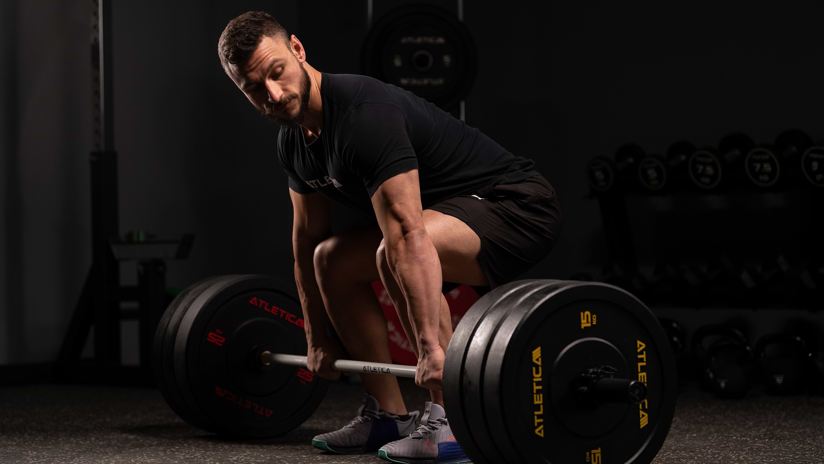 Sportovec provádí mrtvý tah s Atletica High Temp bumper kotouči