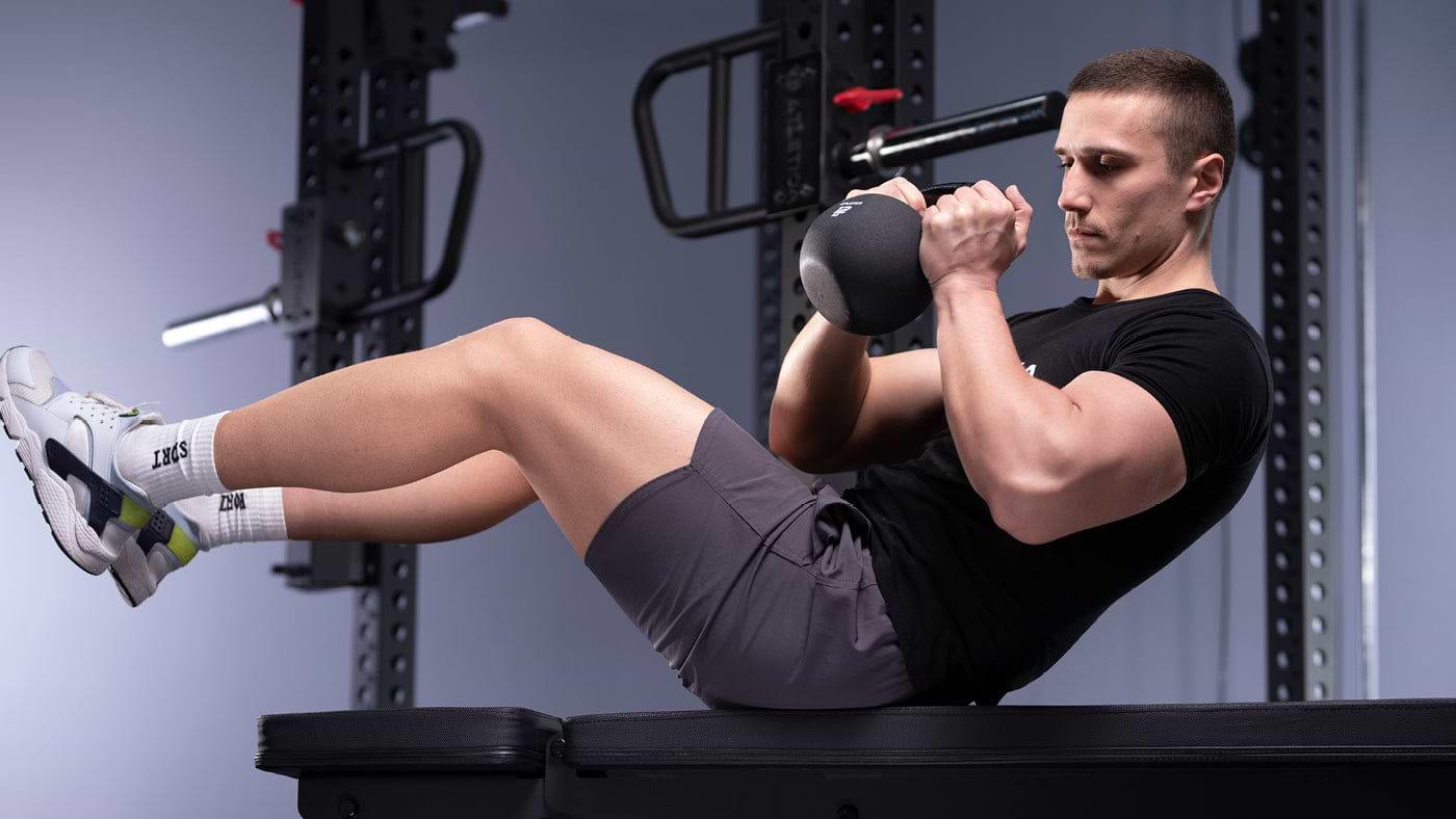 Russian Twists auf der Hantelbank mit Kettlebell