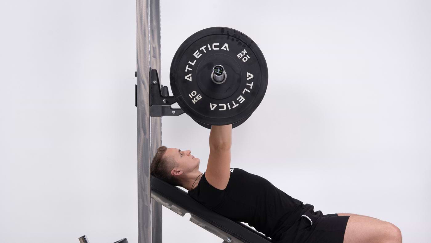 Bankdrücken mit Atletica Langhantel und Bumper Plates am Squat Rack