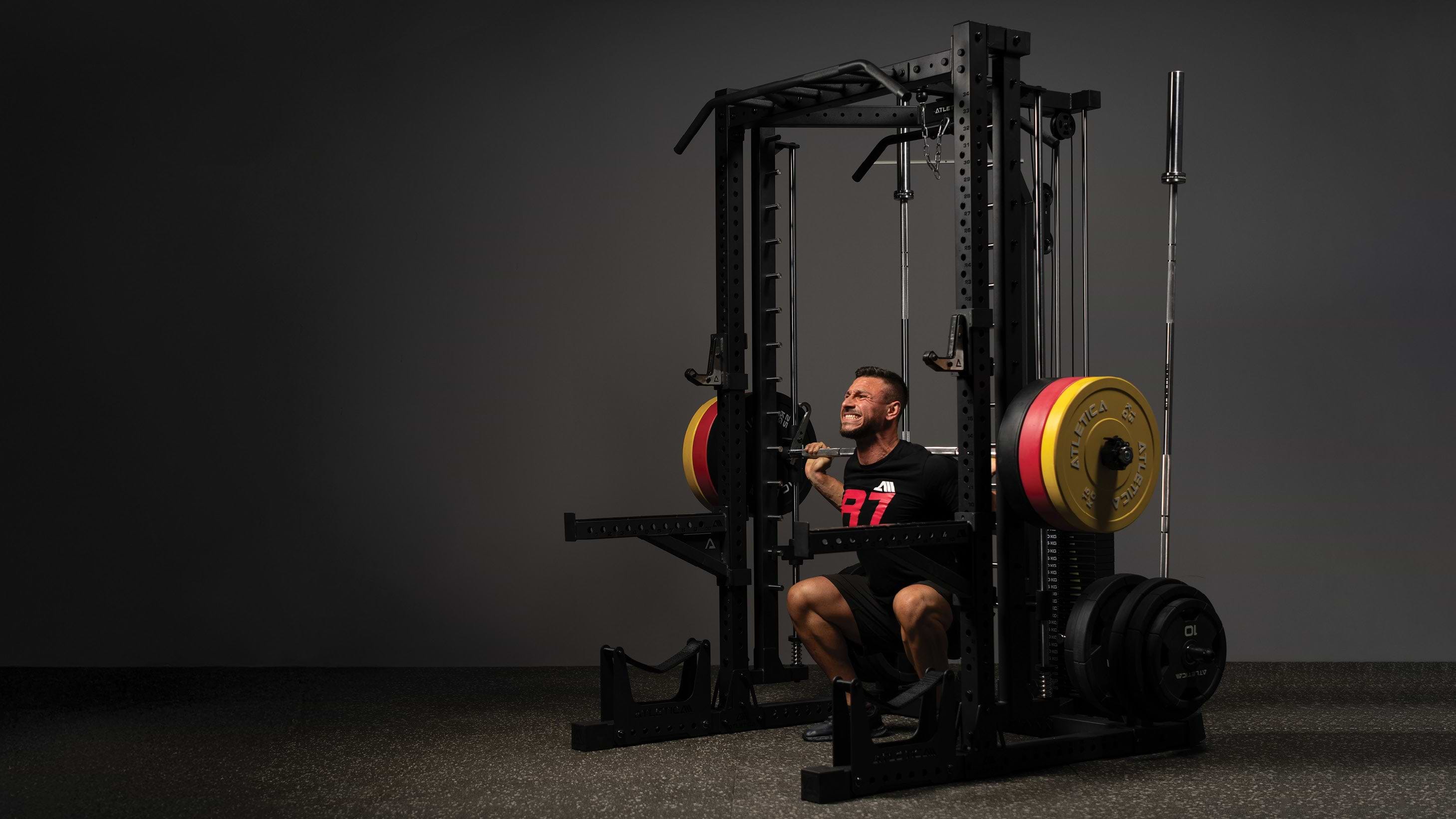 Athlet führt Kniebeuge an der Multipresse des R7 Nemesis Rack aus
