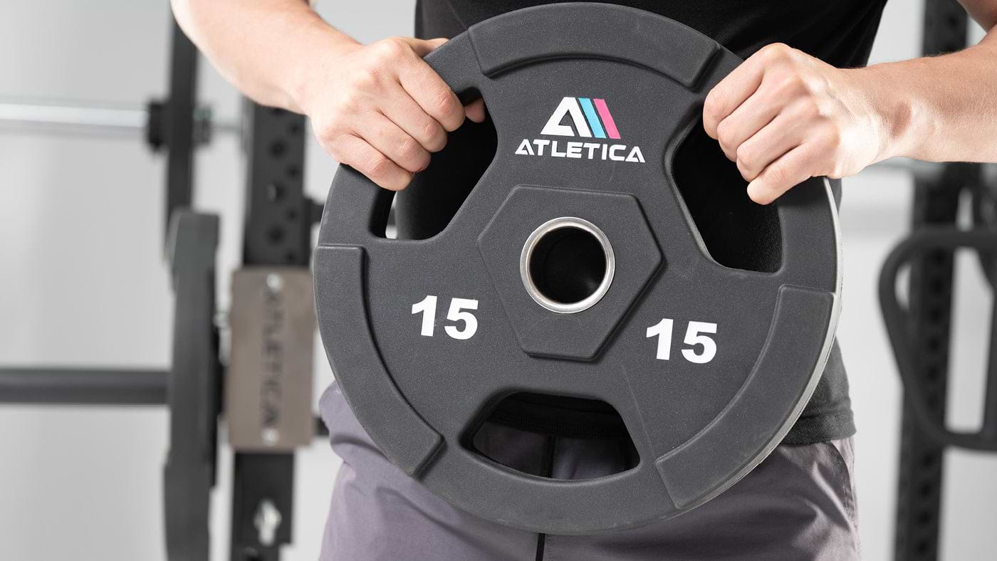 Athlet hält Atletica Gripper Plate Hantelscheibe 15 kg