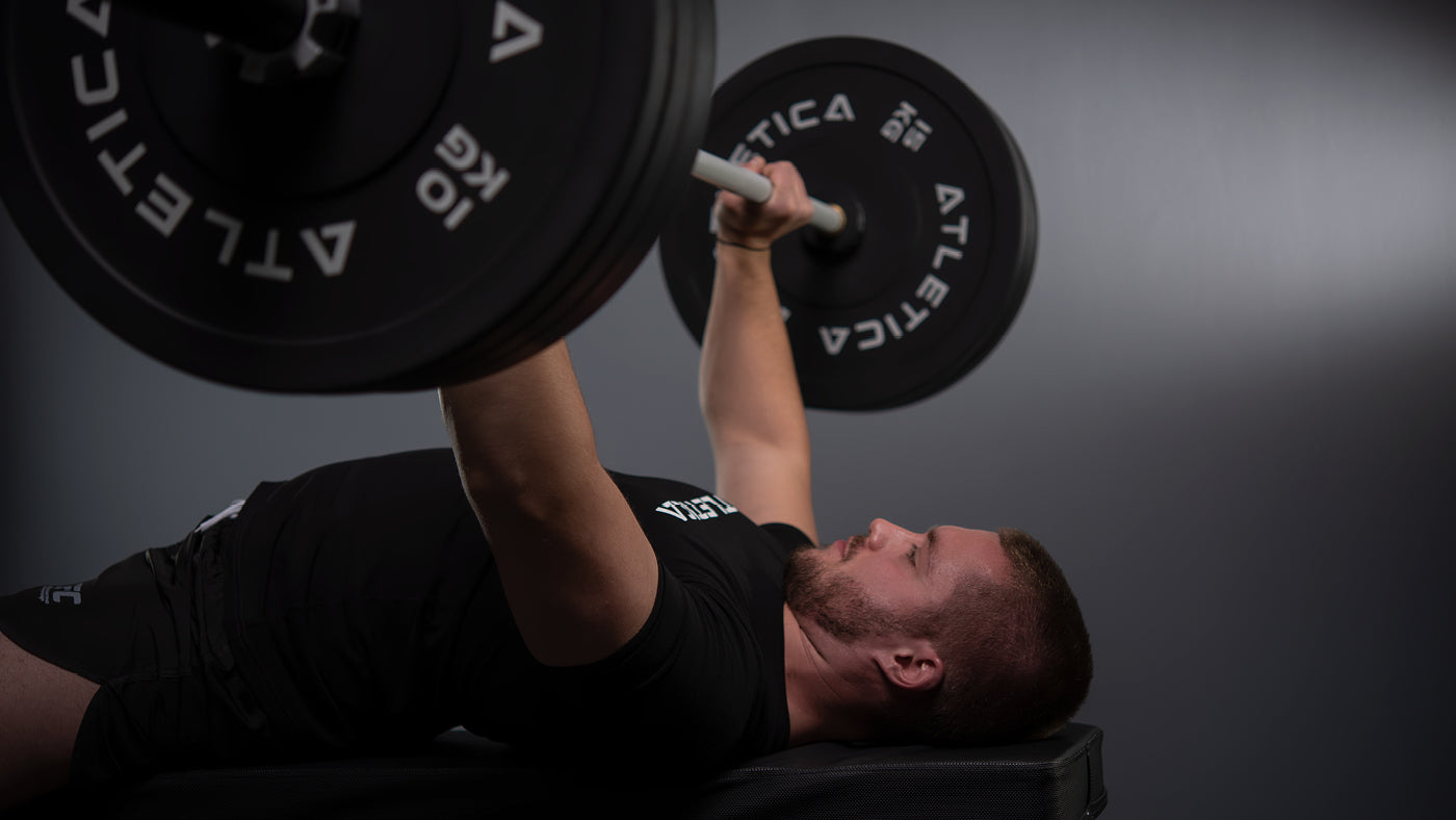 Bankdrücken mit Atletica Langhantel und schwarzen Bumper Plates