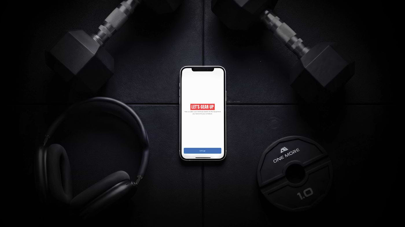 Atletica Training App geladen auf einem Handy neben Hanteln und Gewichten
