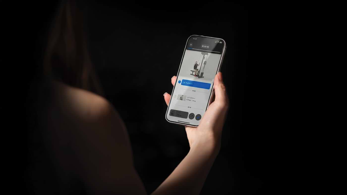 Frau mit Handy in der Hand, Atletica Training App geladen