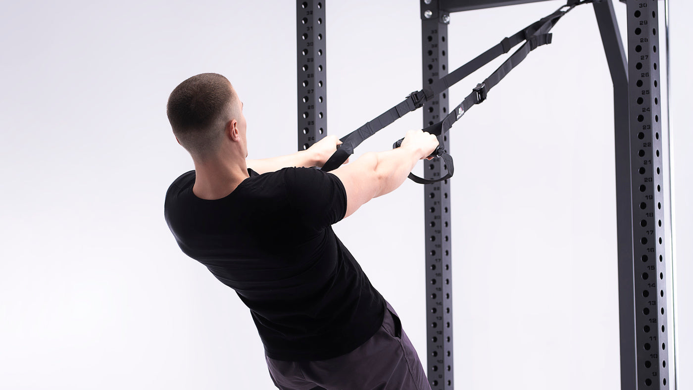 Vue de dos d'un homme en entraînement en suspension avec des poignées en D