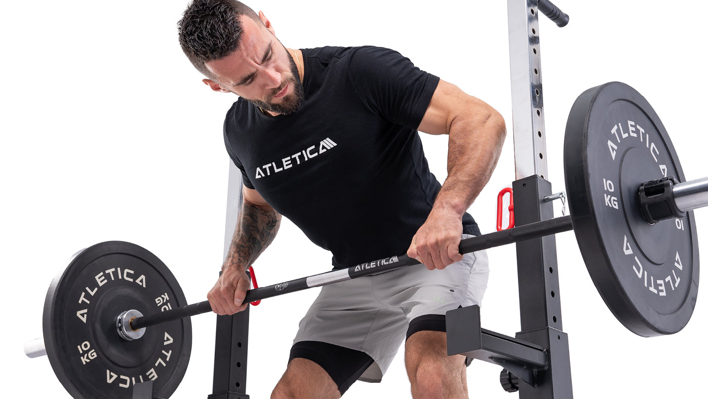 Un athlète au rowing à la barre avec des disques bumper noirs
