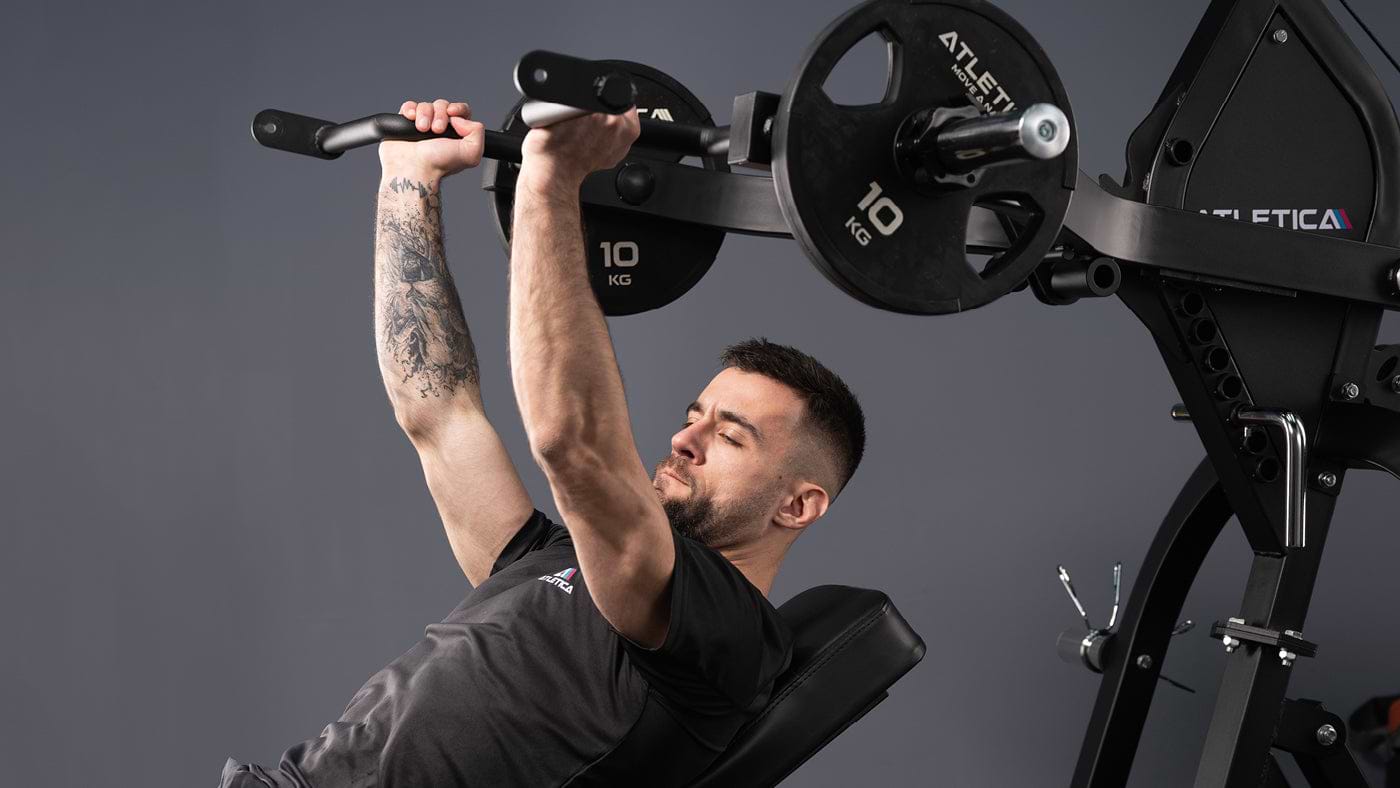 Atleet doet schouderdrukken aan het X-Tron multistation