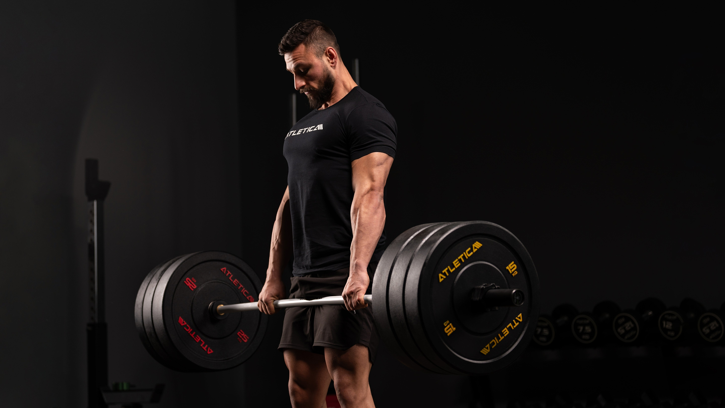 Mand laver dødløft med tungt lastet Atletica vægtstang og High Temp bumper plates