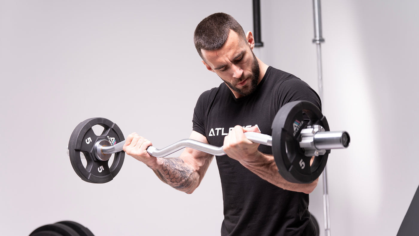 Homme faisant un curl biceps avec une barre EZ et des disques Gripper de 5 kg