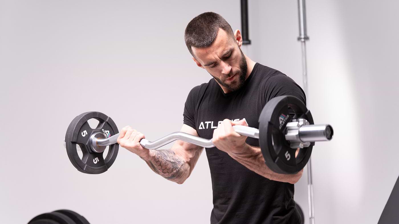 Homme faisant un curl biceps avec une barre EZ et des disques Gripper de 5 kg