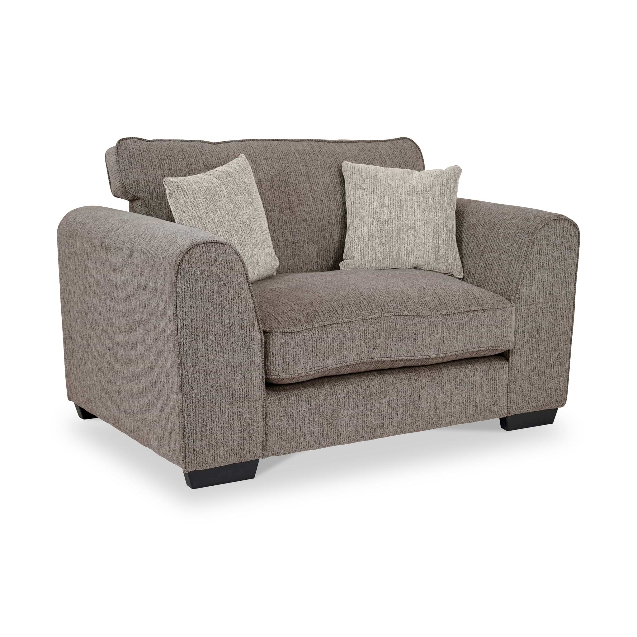 Thornby Snuggle Armchair Mink Natural from Roseland Furniture postitioned at an angle highlighting the black legs and textured details of the armchair with simple piping around the edges and 2 cream cushions