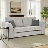 Thornby 3 Seater Sofa Light Grey Charcoal from Roseland Furniture in a living room with two french doors behind. on the right is a plant and on the white walls is a painting, the flooring is a light oak and is covered with a cream rug. 