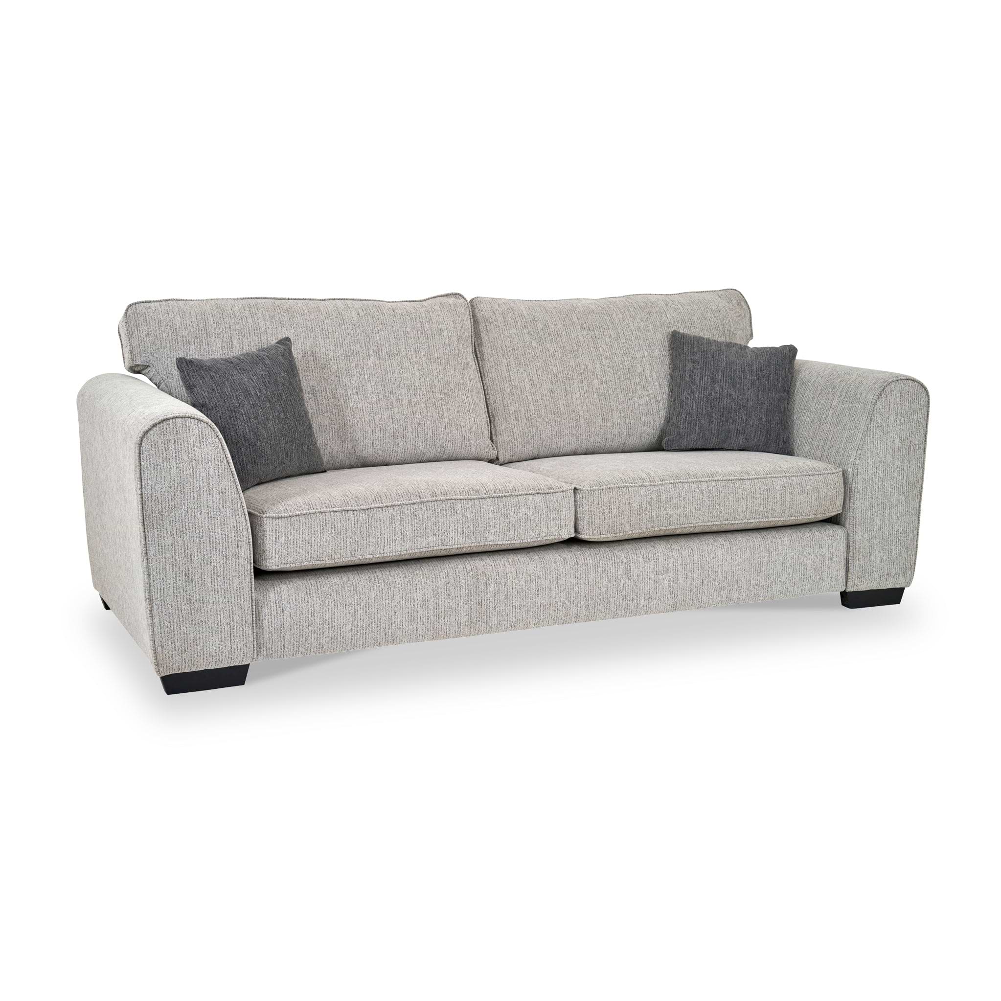 Thornby 4 Seater Sofa Light Grey Charcoal from Roseland Furniture postitioned at an angle highlighting the black legs and textured details of the sofa with simple piping around the edges and two grey cushions.